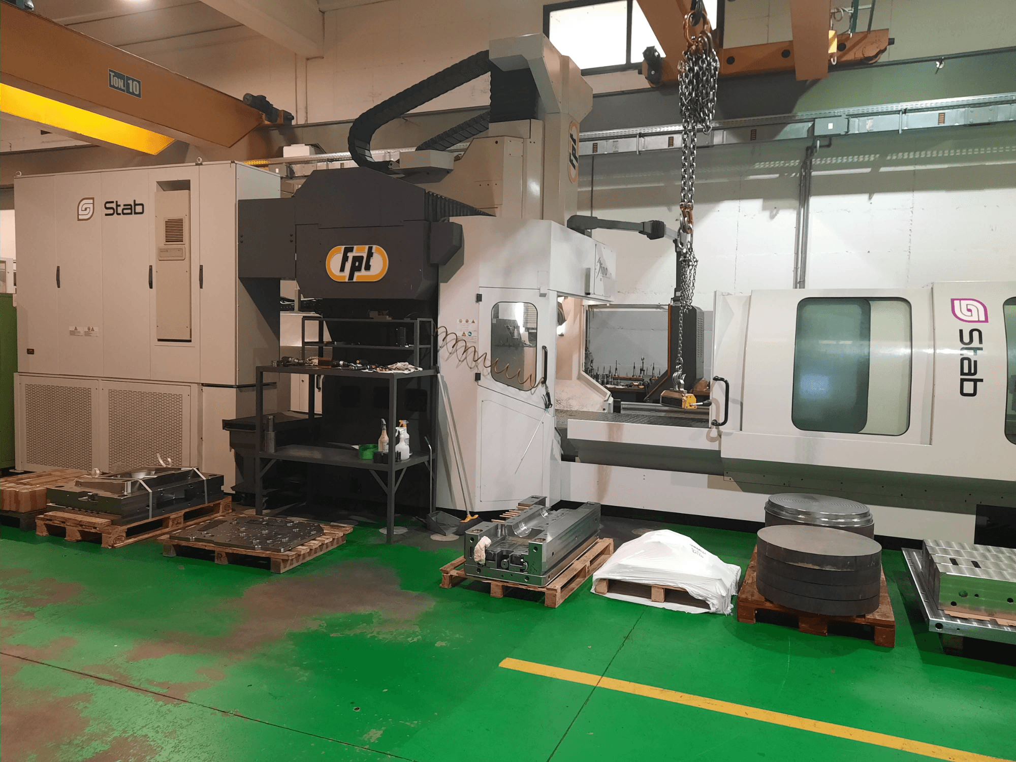 FPT DINO bed type milling machine in a workshop, shown from a front view with nearby tooling and materials on pallets.