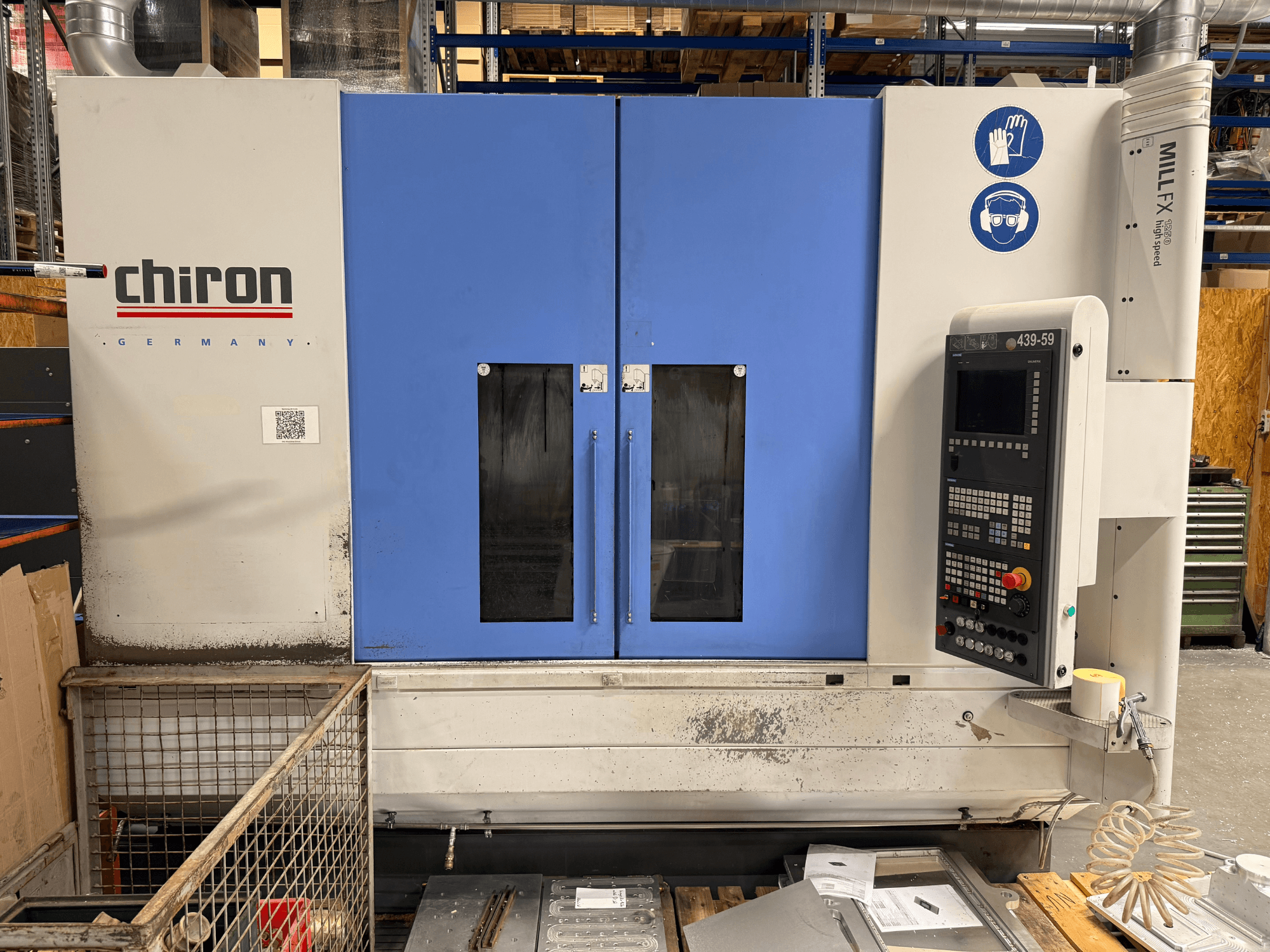 CHIRON MILL FX 1250 vertical machining center, front view, featuring control panel and safety symbols, ready for precision work.