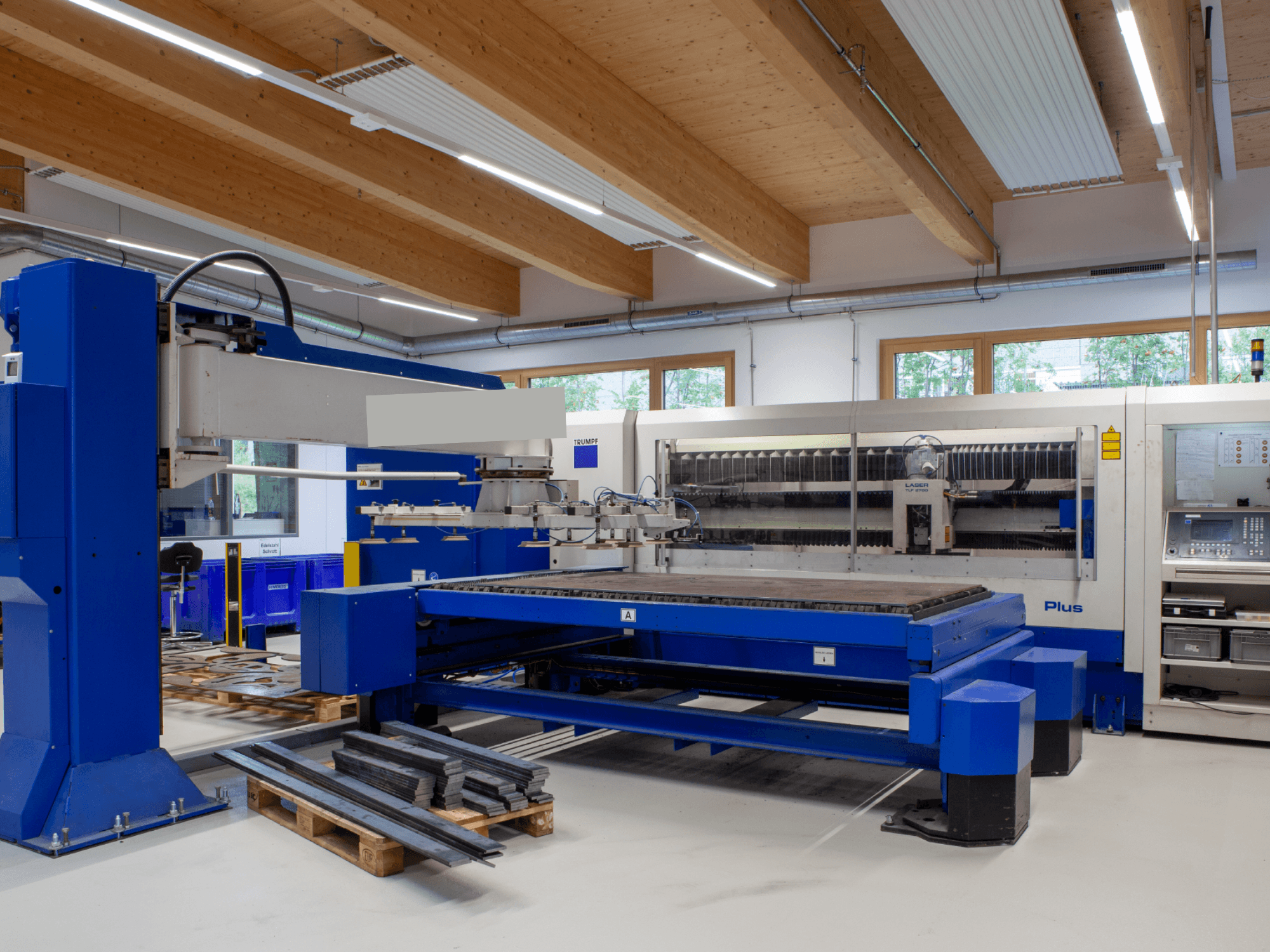 TRUMPF TRUMATIC L 2530 Plus CO2 laser cutting machine in a workshop, showcasing a large cutting bed and industrial design.