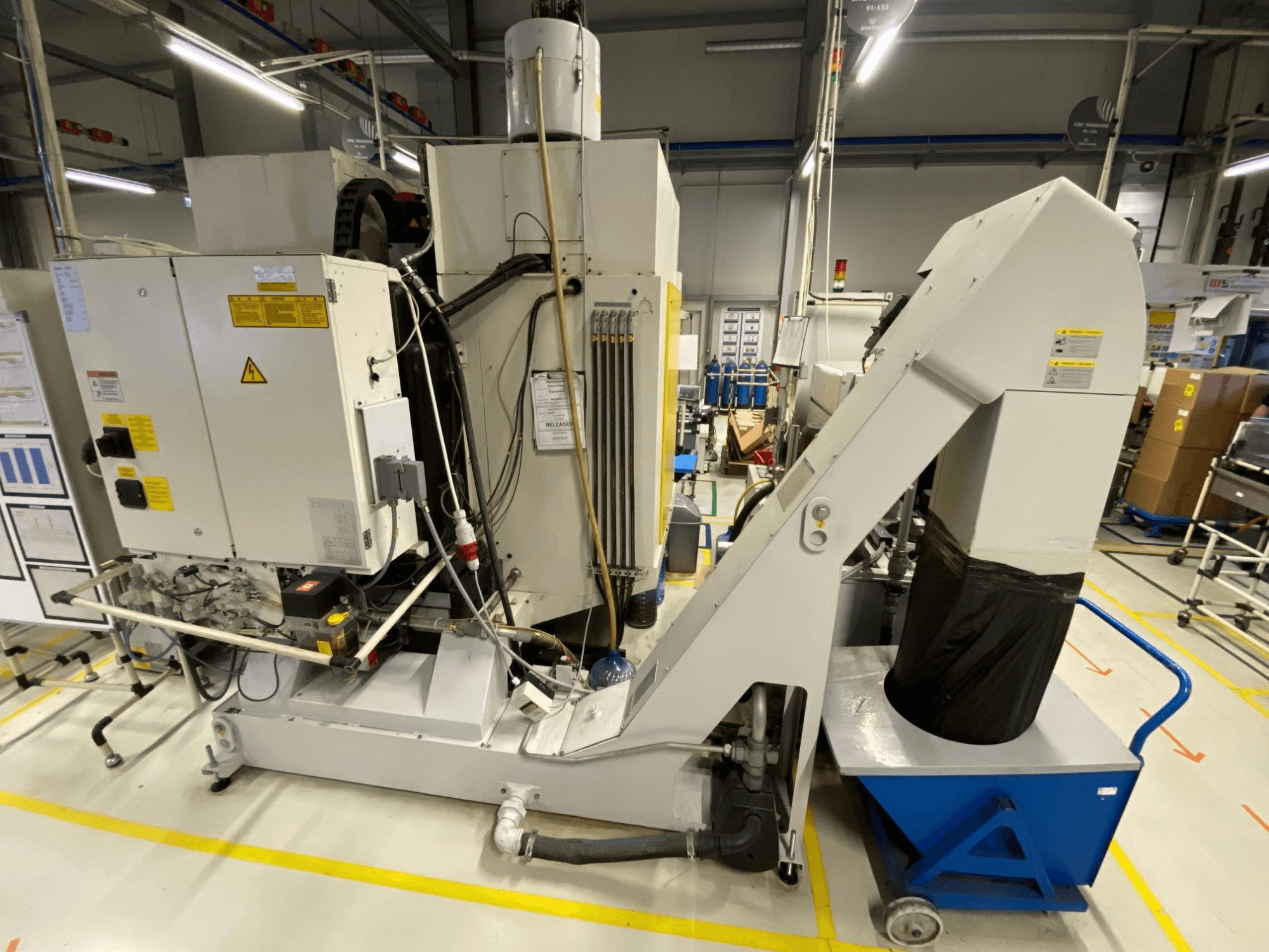 FANUC ROBODRILL α-D21LiB vertical machining center front view, showcasing electrical components and output chute.
