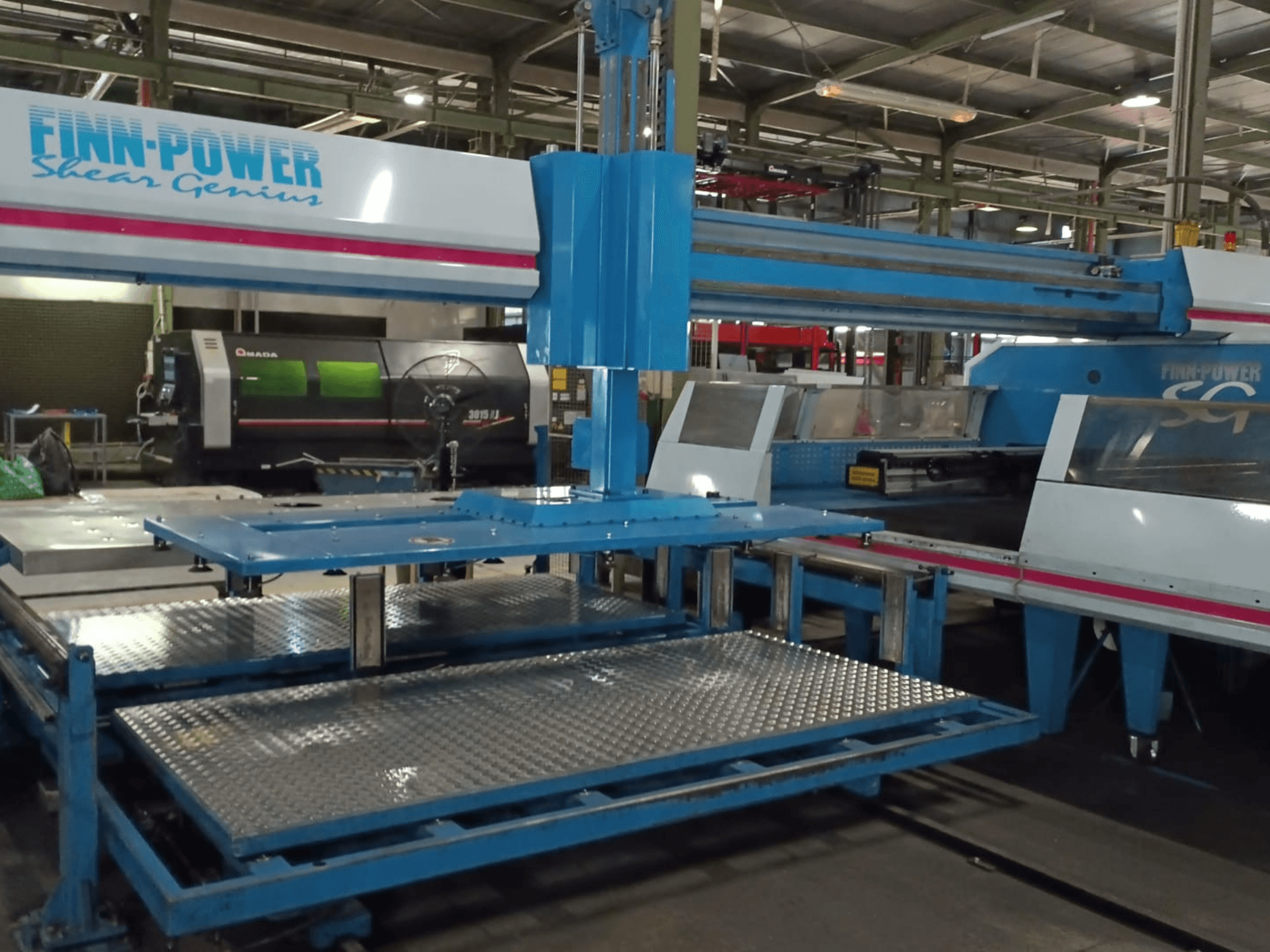 Finn-Power SG6 Shear Genius CNC punching machine in a front view, showcasing metal tables and structural features.