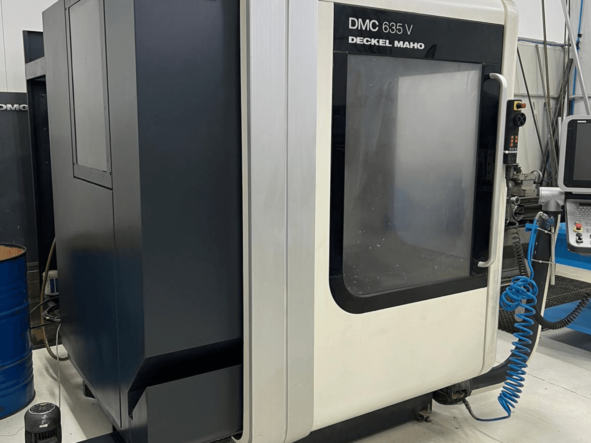 DMC 635 V milling machine by Deckel Maho, side view showing control panel and partially open access door.