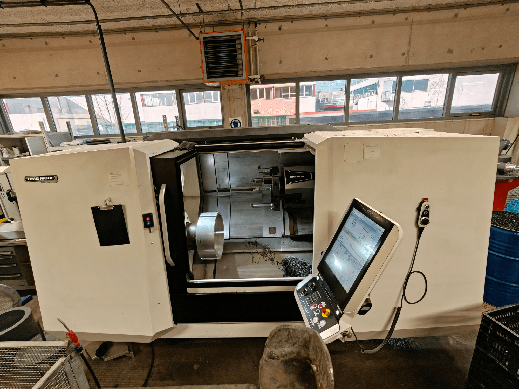 Front view of a DMG MORI CLX 550 horizontal turning machine, showcasing the control panel and open work area.