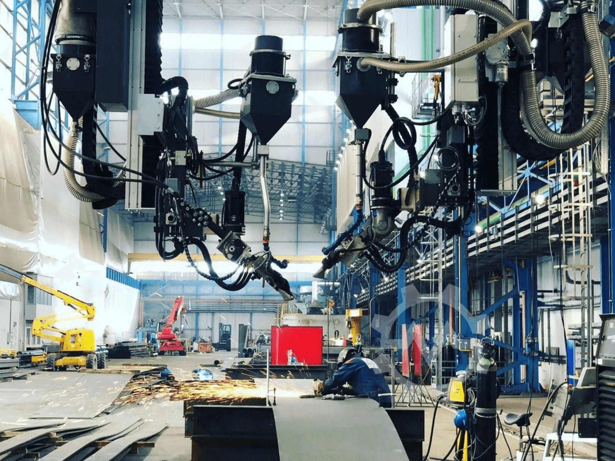 Robotic cutting machine in an industrial setting, with sparks flying, viewed from the side; features multiple attachments and hoses.