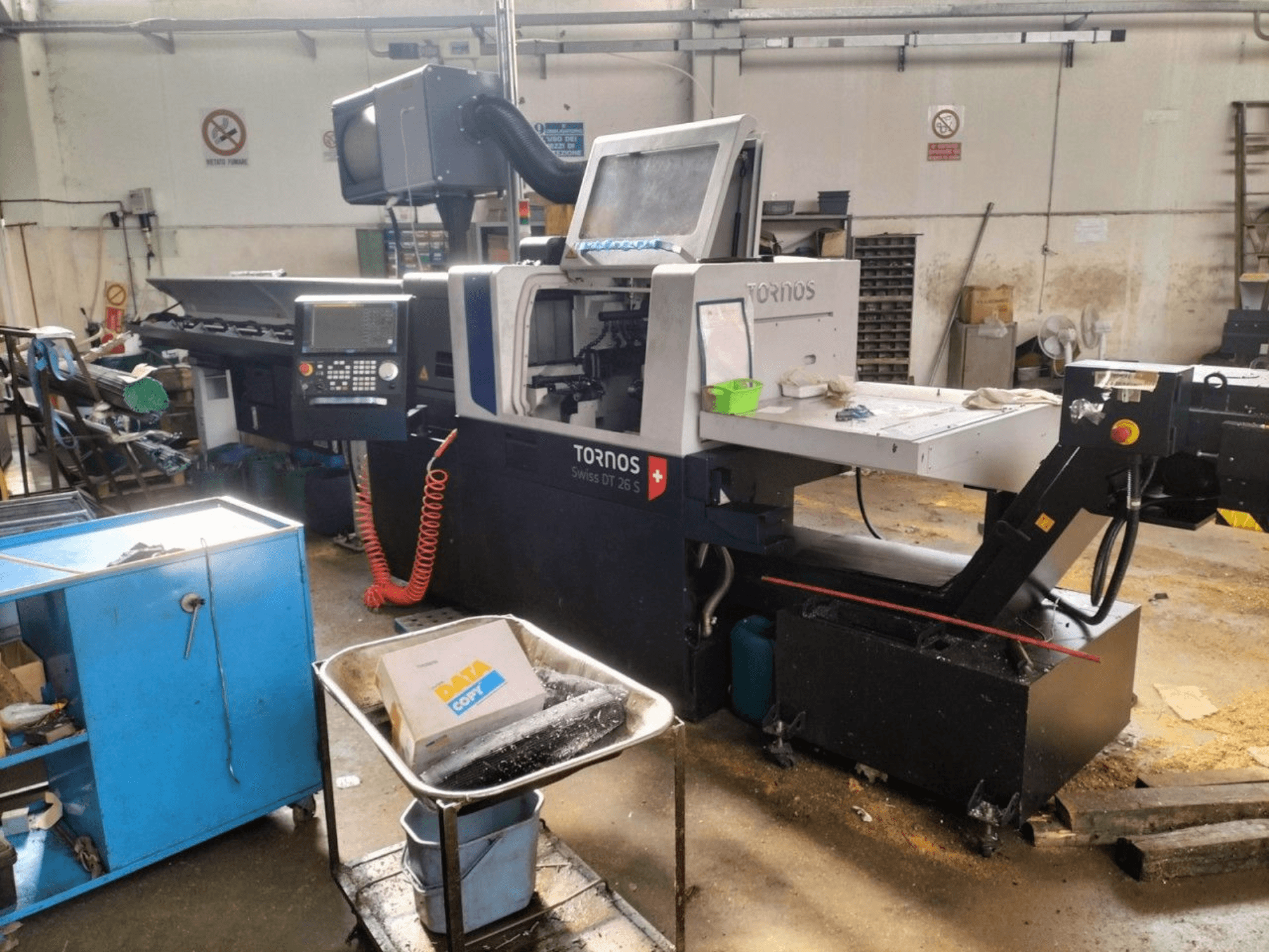 TORNOS Swiss DT 26 S Swiss Type Turning Machine, front view, showcasing control panel, workspace, and surrounding industrial environment.