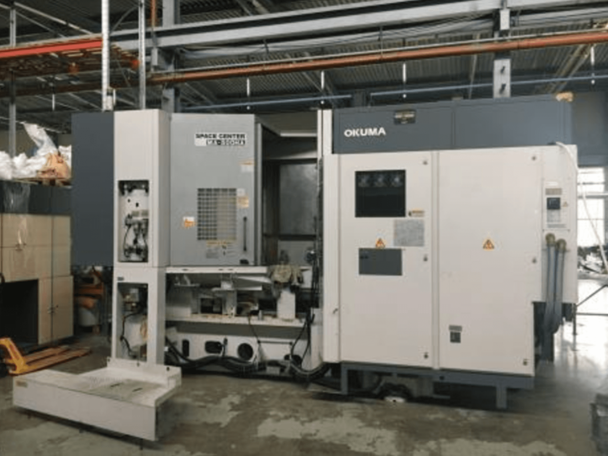 Front view of Okuma SPACE CENTER MA-500HA horizontal machining center with control panel and mechanical components visible.