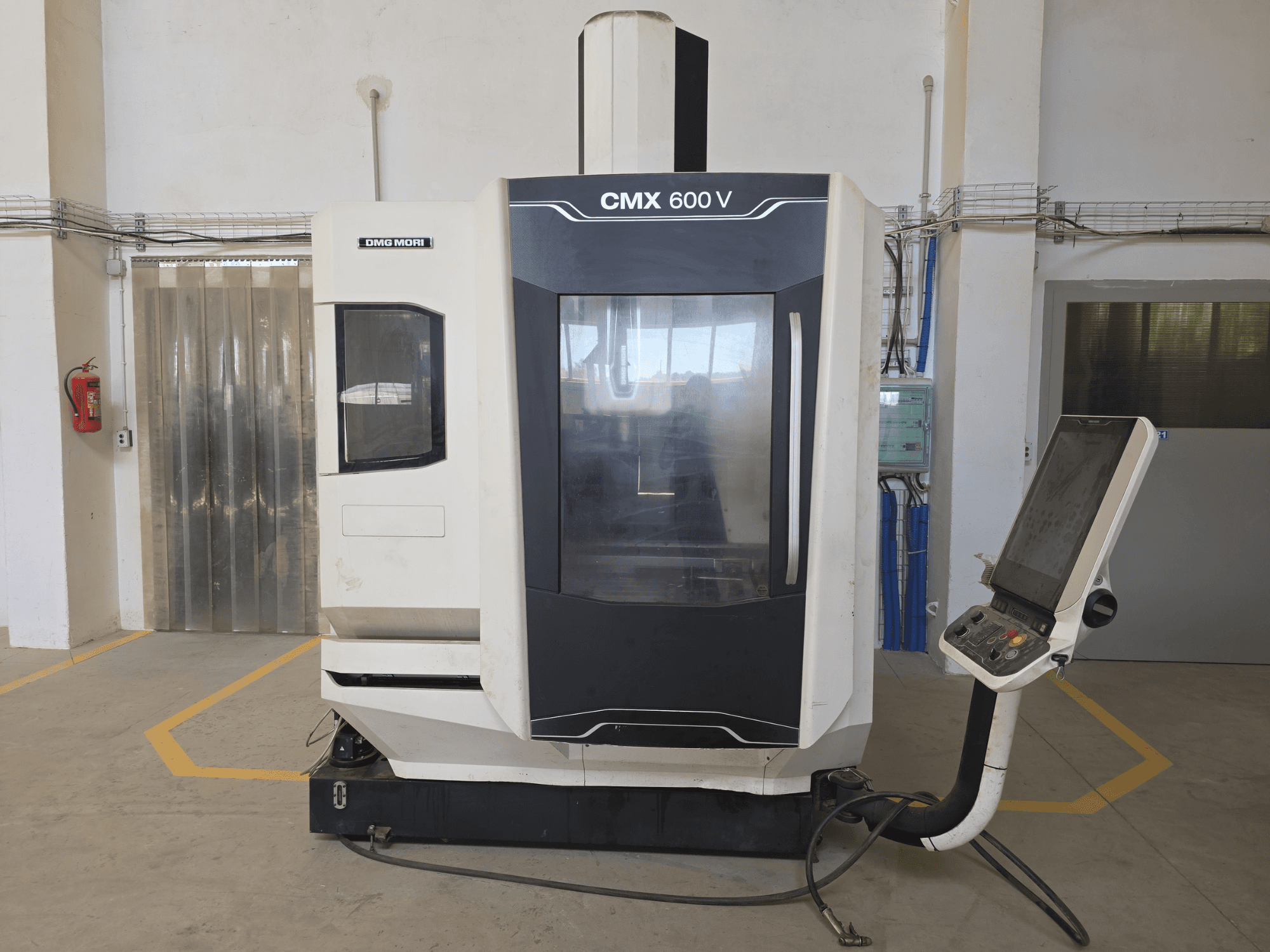 DMG MORI CMX 600 V vertical machining center, front view, showcasing control panel and large transparent window.