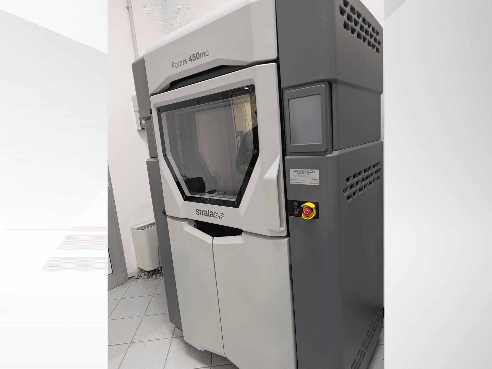 Fortus 450mc plastic 3D printer shown in side view, featuring a clear front panel and control buttons on the side.