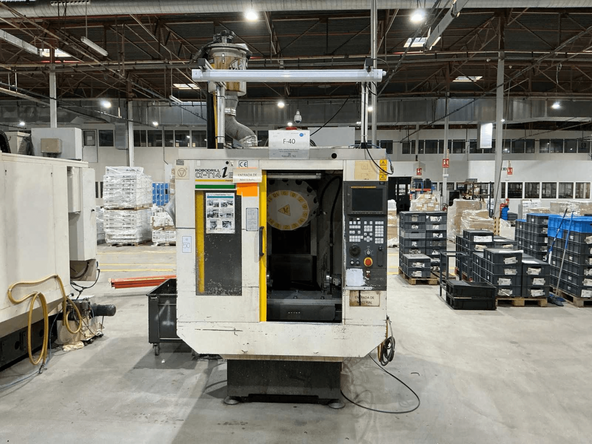 FANUC ROBODRILL α-T14iB vertical machining center in a factory, front view showing control panel and tool holder.