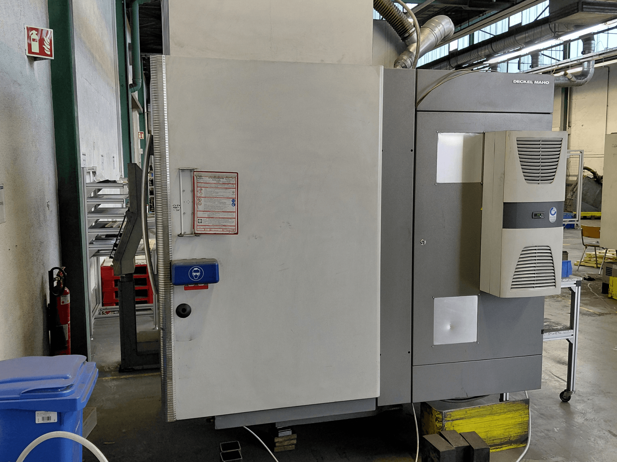 Side view of DECKEL MAHO DMC 635 V vertical machining centre with control panel and safety labels visible.