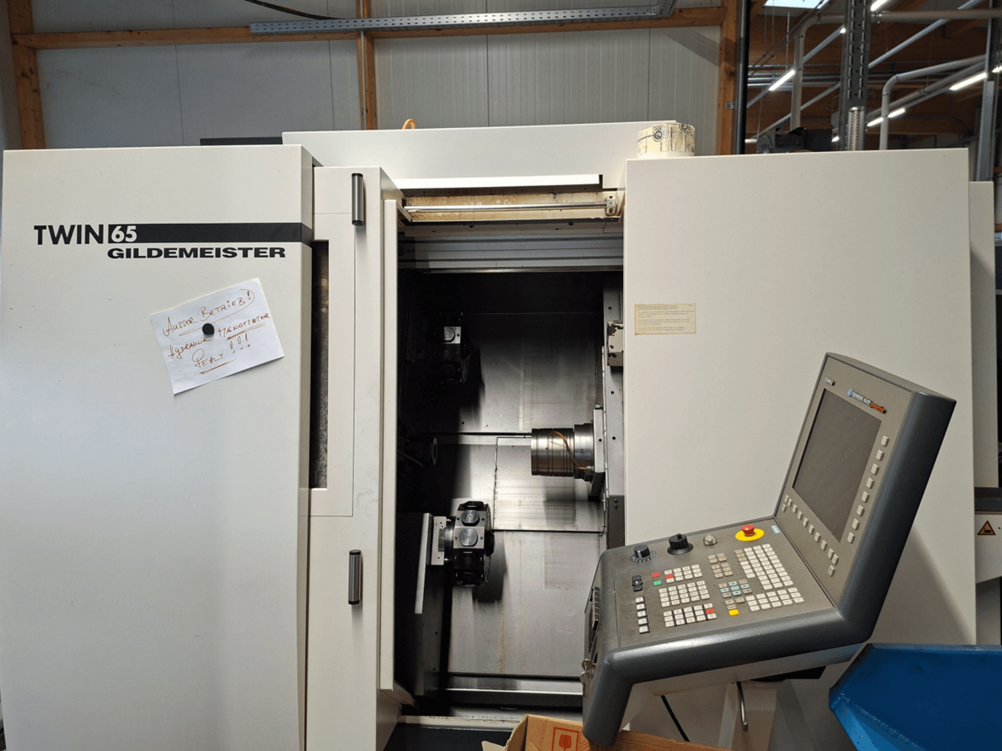Gildemeister TWIN 65 CNC lathe, front view showing control panel and partially open chamber with visible machinery.