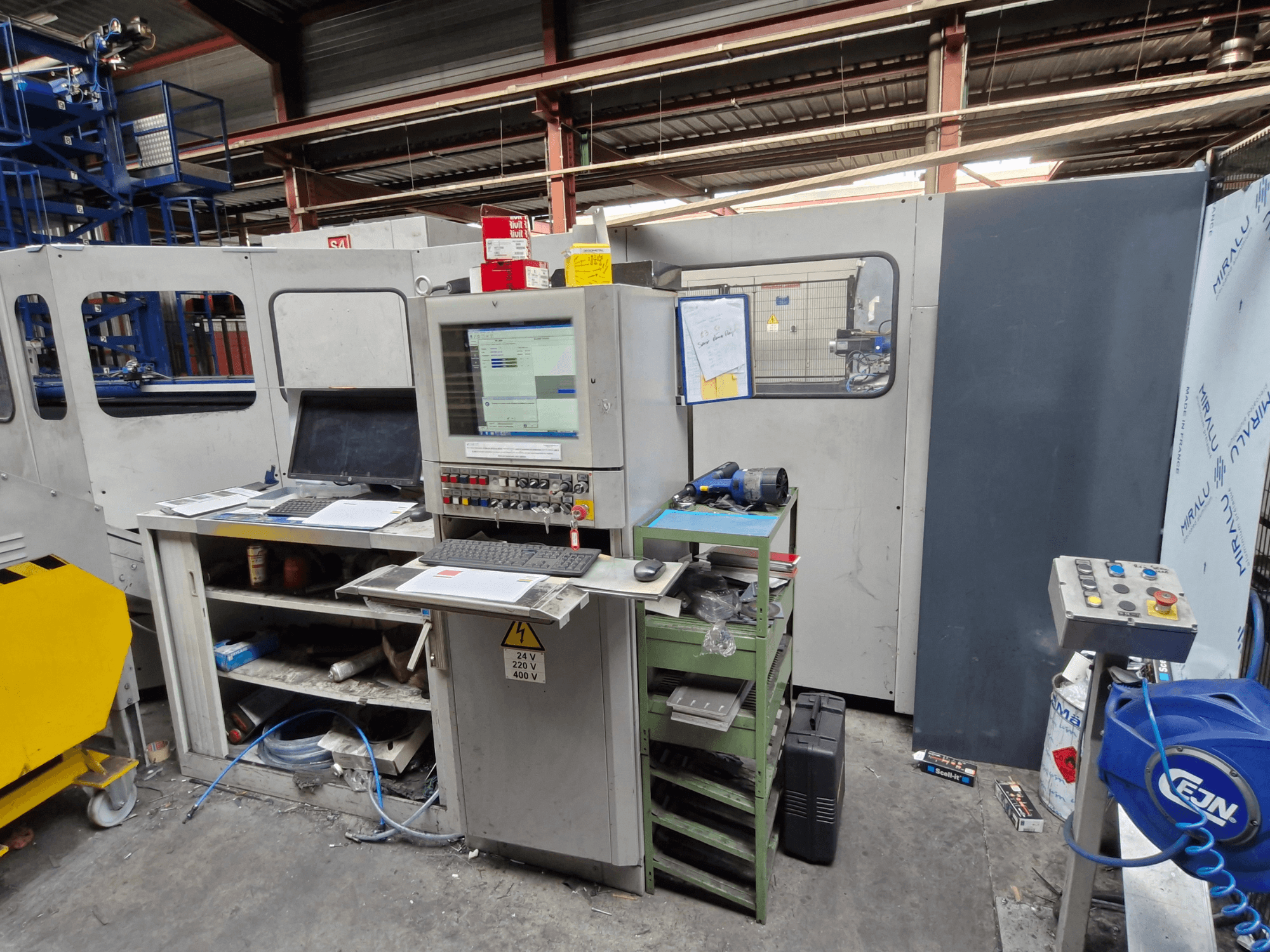 CNC Punching Machine Salvagnini S4-40 in a workshop, featuring a control panel with monitors and tools, front view.