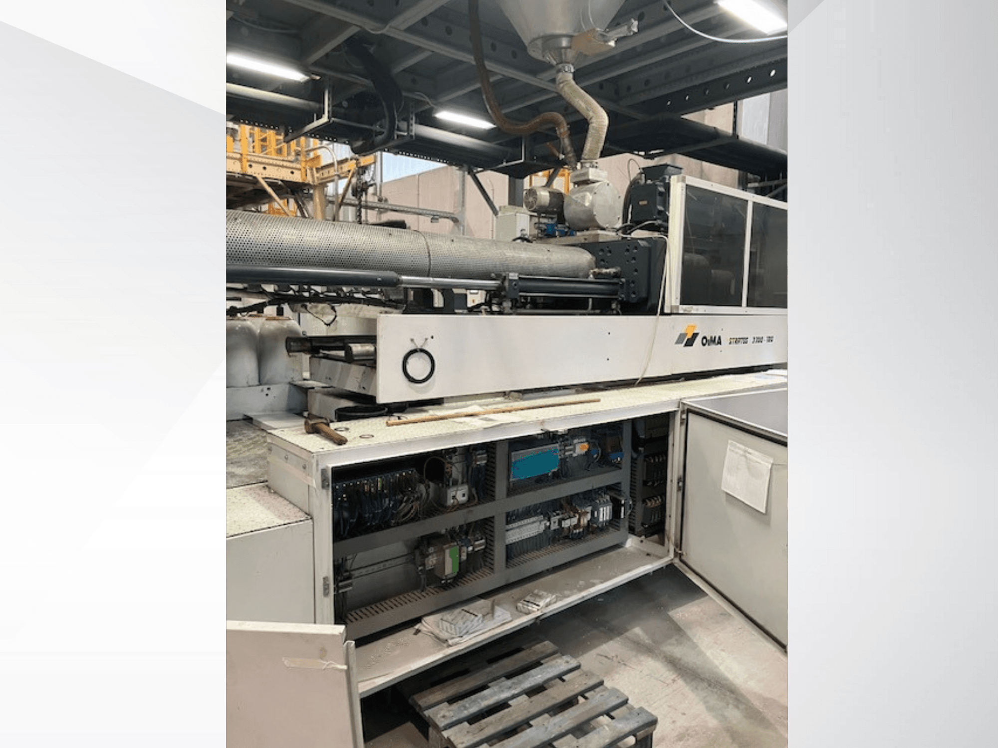 Front view of OMA Extruder 3500, showcasing operational parts, control panel, and wiring details. Heavy machinery in industrial setting.