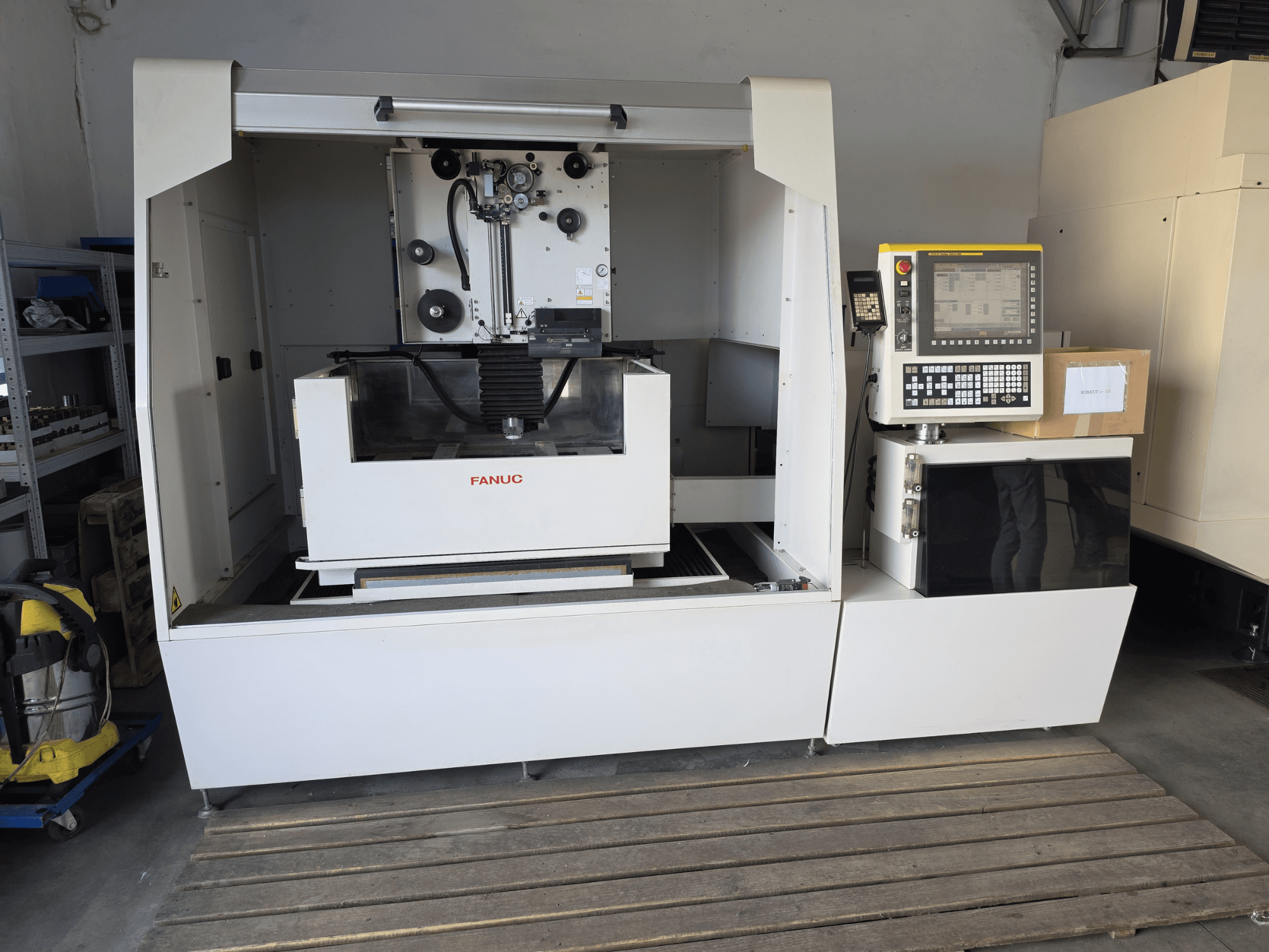 FANUC ROBOCUT alpha-1iD Wire EDM machine, front view showing control panel, work area, and compact design in workshop setting.