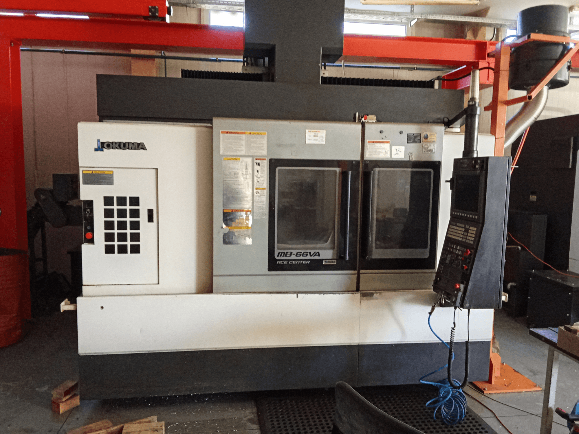 Okuma MB-66VA vertical machining centre, front view showing control panel and dual viewing windows for tooling access.