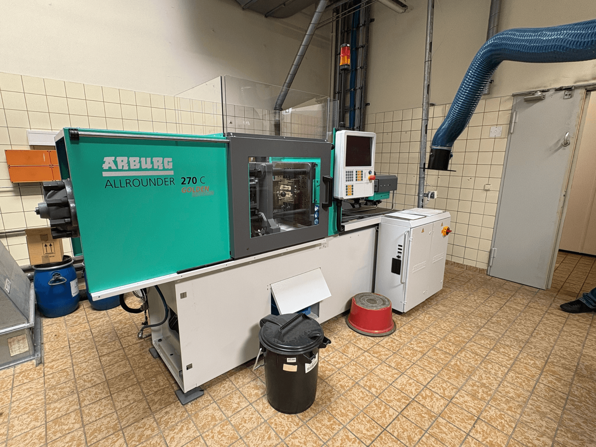 Hydraulic injection moulding machine Arburg ALLROUNDER 270 C from side view, featuring controls and connected equipment.