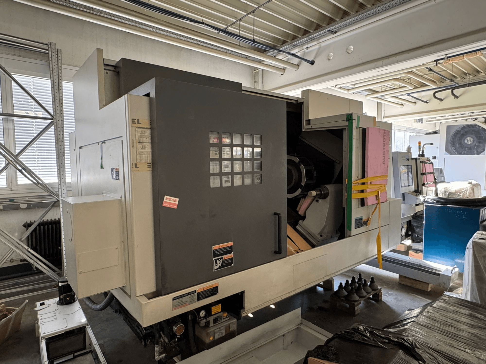 MORI SEIKI NL 3000 MC/700 horizontal turning machine, front view with control panel, storage area, and protective wrap.