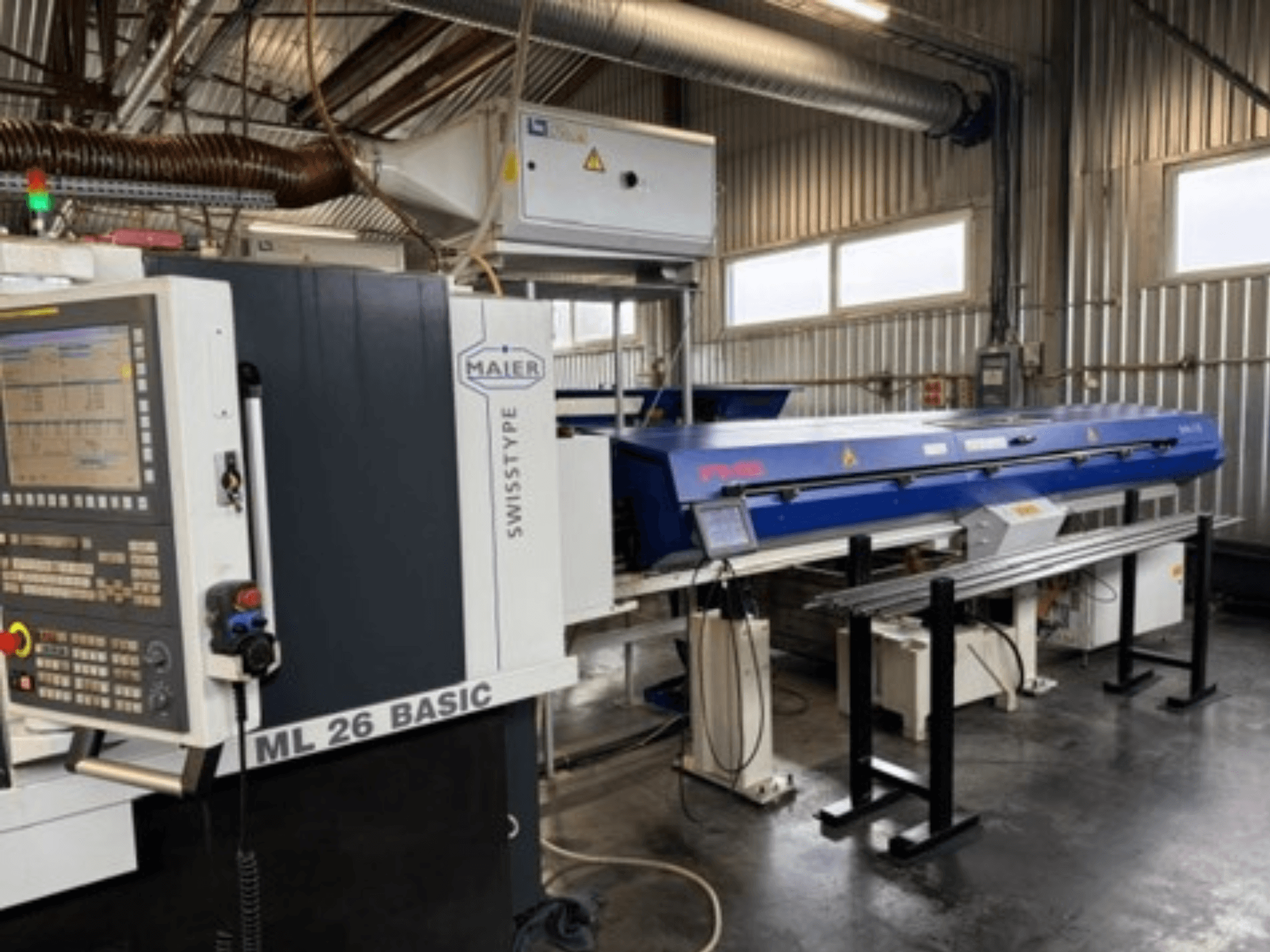 Alt text: Front view of Maier ML26 C5Y Swiss Type Turning Machine with control panel and attached blue device in industrial setting.