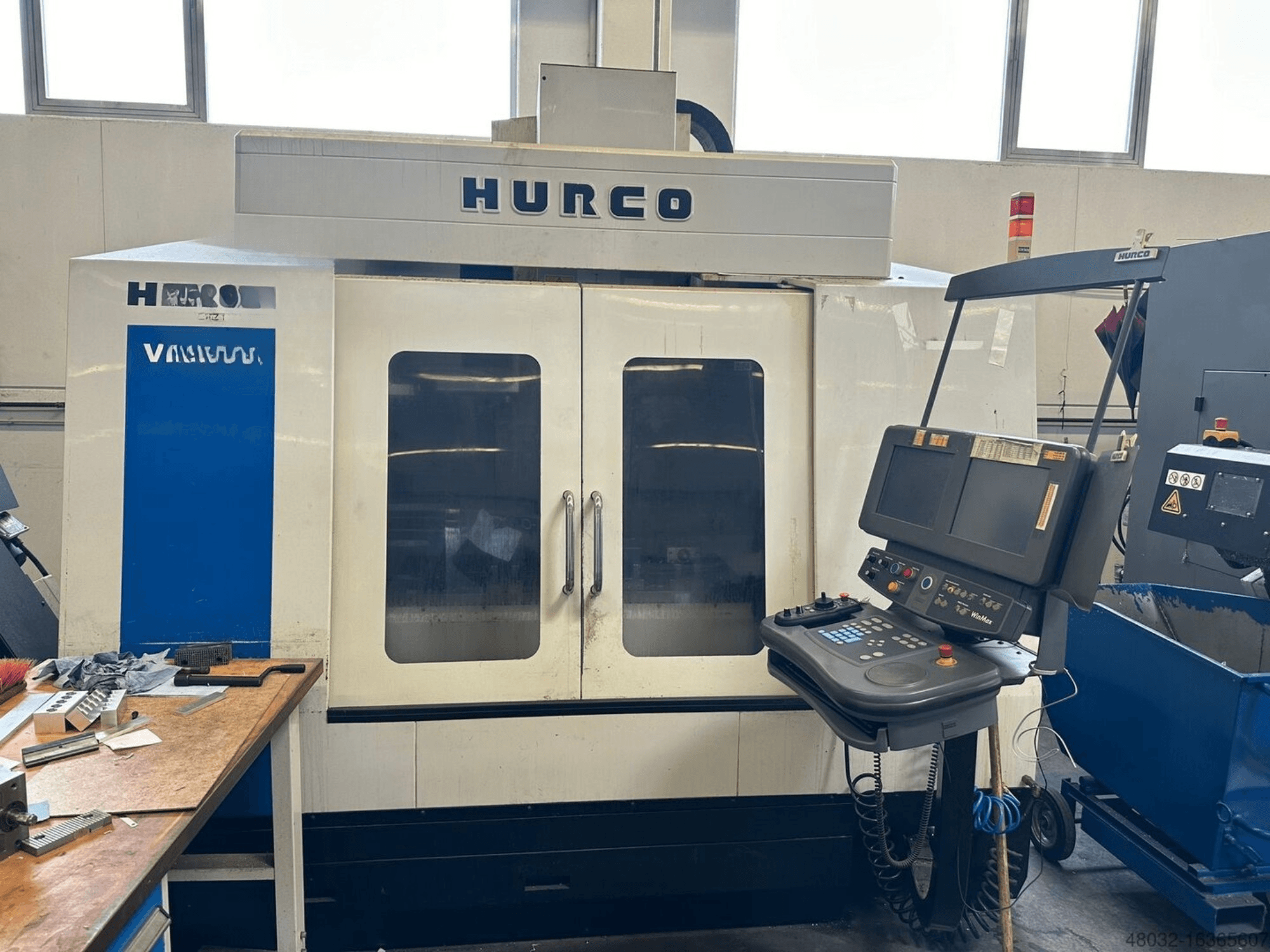Hurco VMX42t vertical machining center featuring a control panel and large viewing windows, shown in a workshop setting.