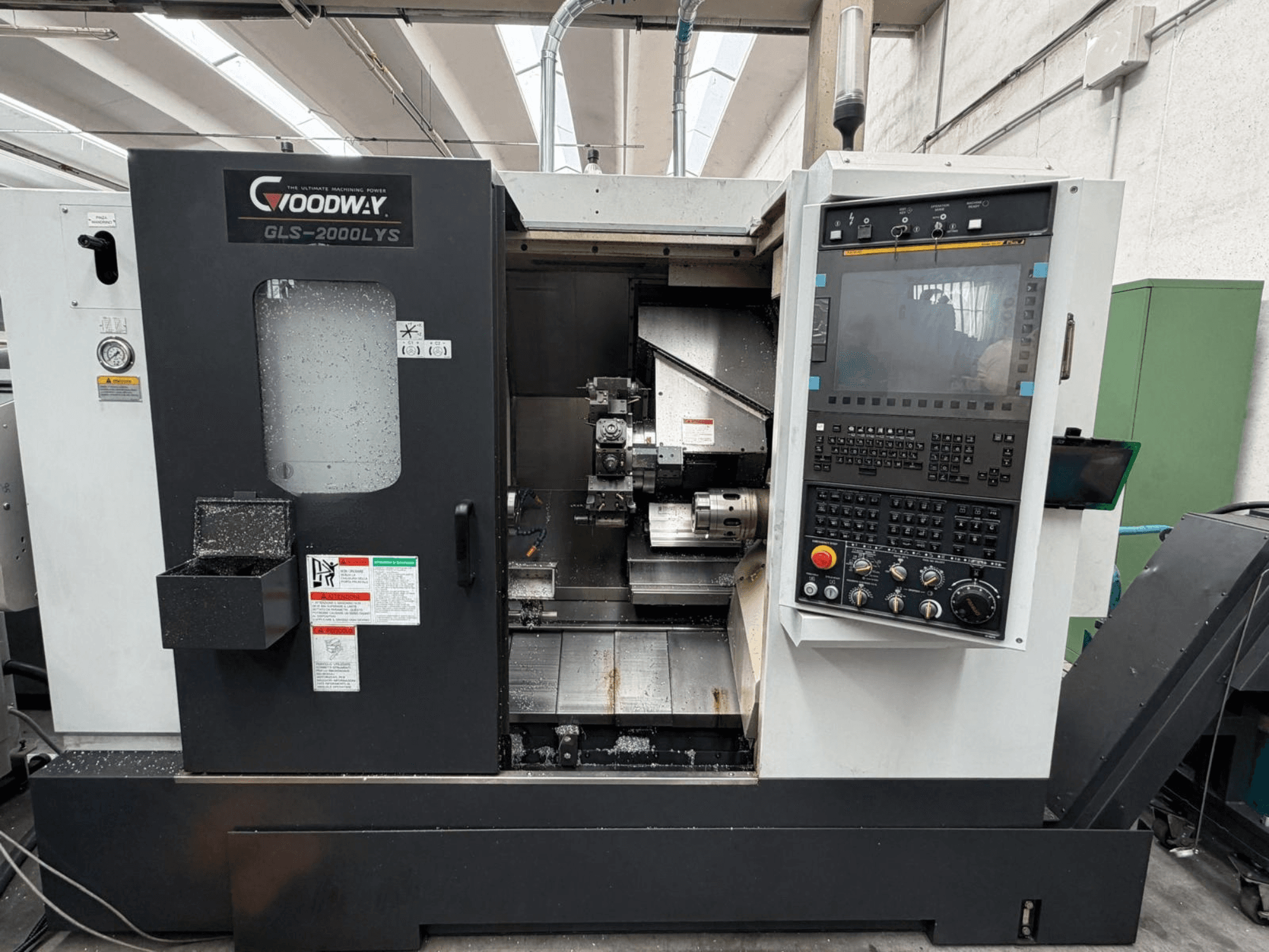 Goodway GLS-2000LYS horizontal turning machine from a front view, featuring control panel and visible metal shavings.