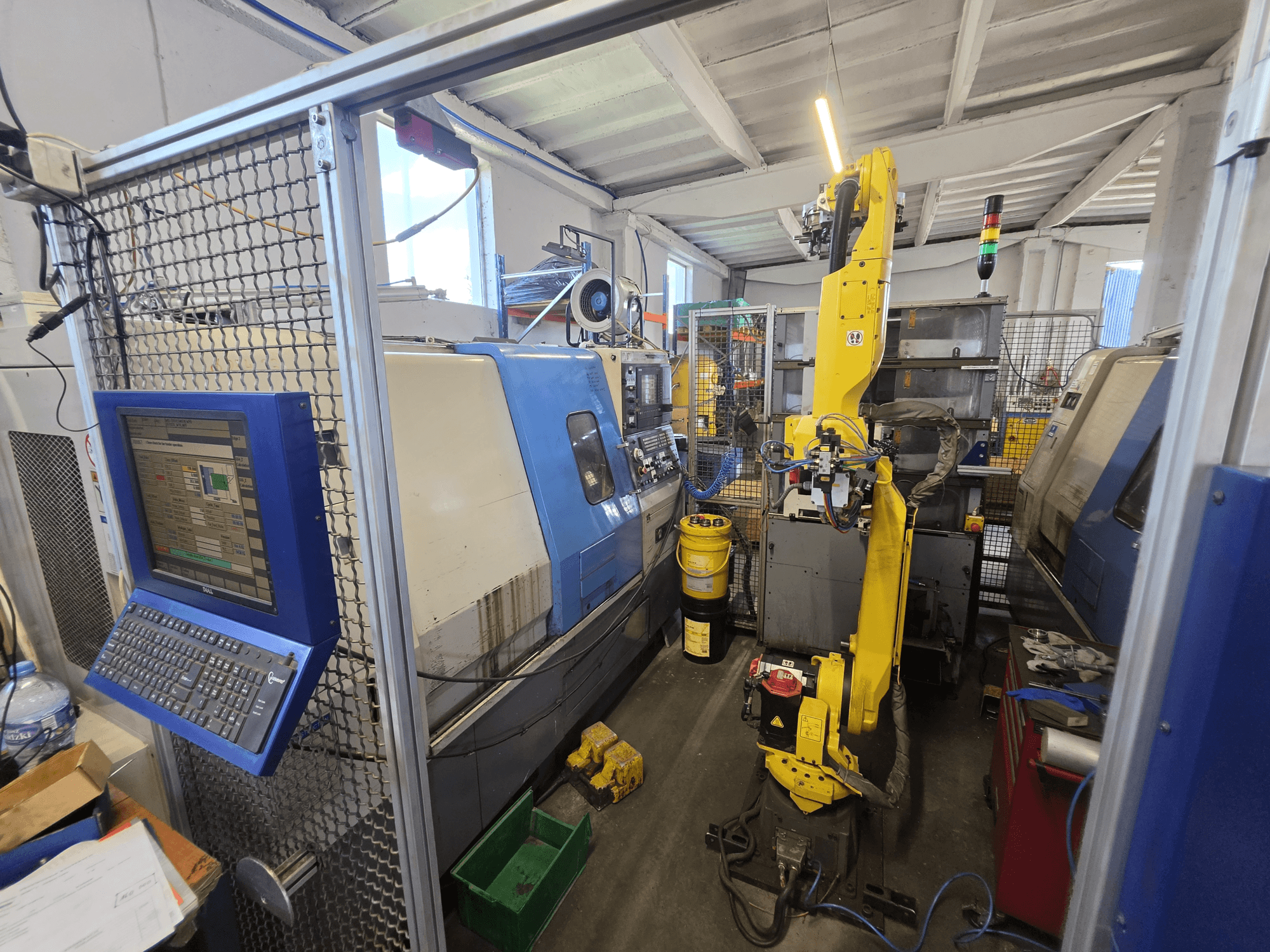 Hyundai HIT-200C horizontal turning machine with FANUC M-20iA robot, front view showing control interface and machinery setup.