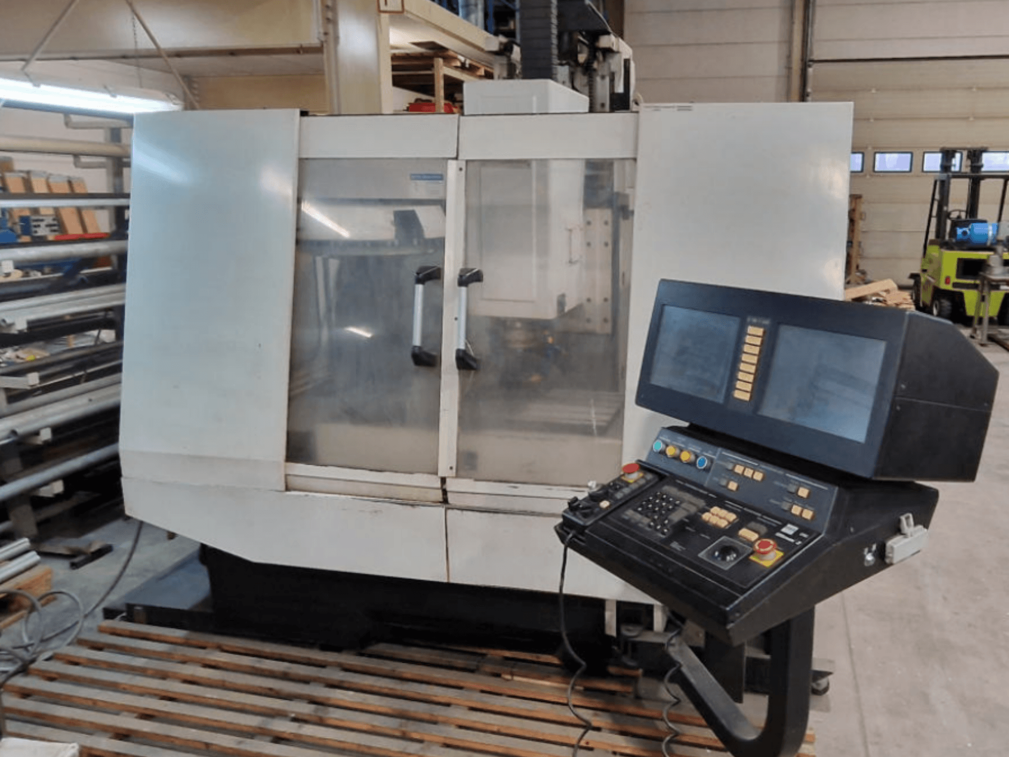 Hurco BMC30AP vertical machining center, front view showing control panel with buttons and screens, on a wooden pallet.