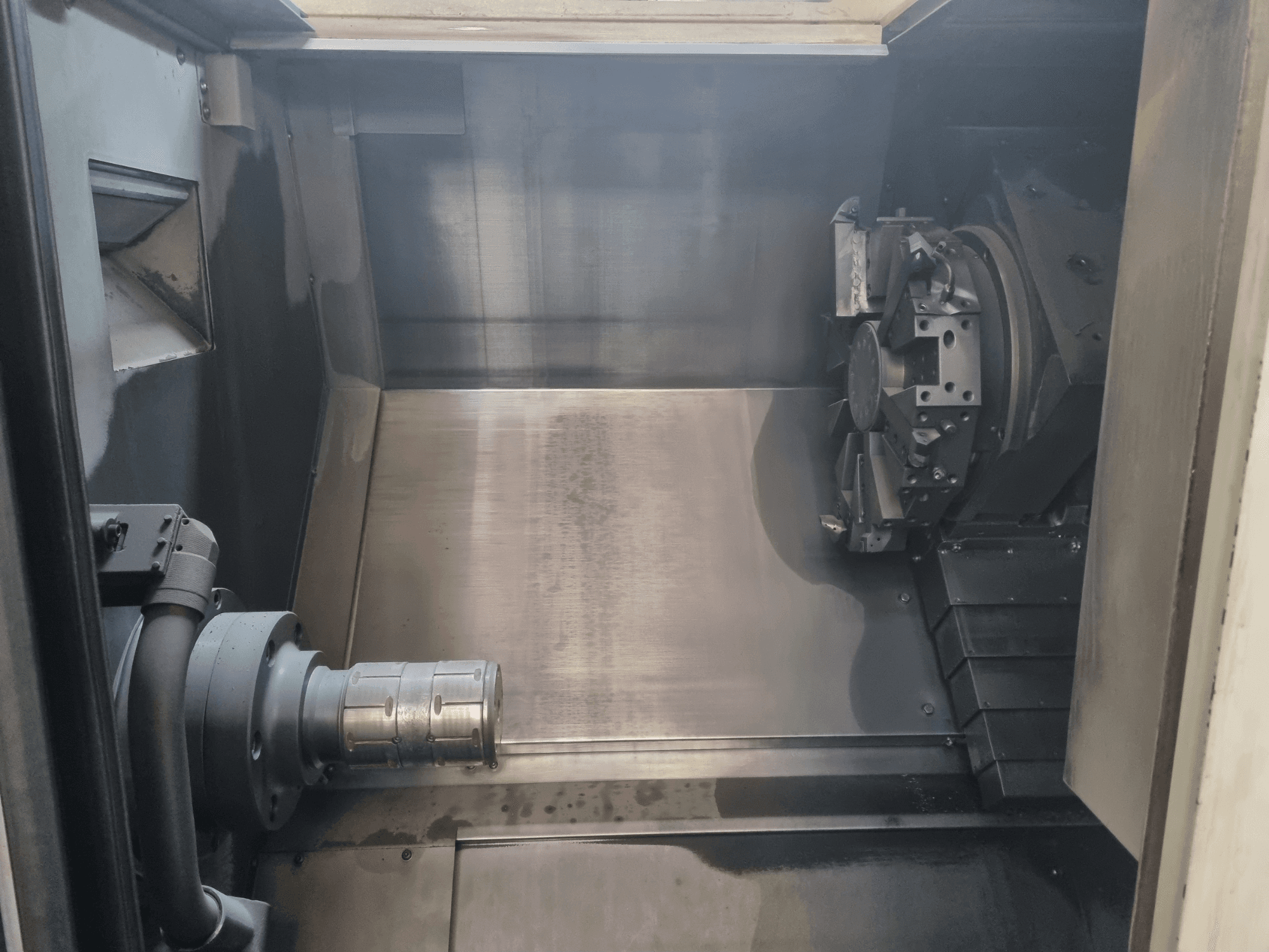 Interior view of a CNC machine showing a metal work area, tool holder, and chuck; emphasizes precision engineering.