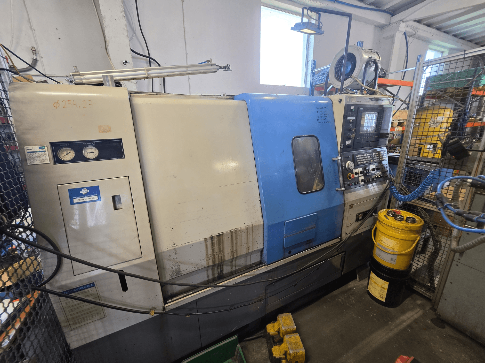 Hyundai HIT-200C horizontal turning machine, front view, features control panel, gauges, and safety instructions visible.