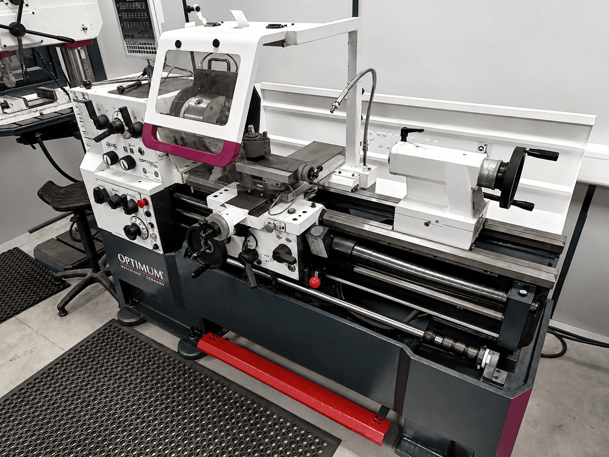 Optimum TH 4610 horizontal turning machine, side view, features controls, chuck, and workspace with robust design.