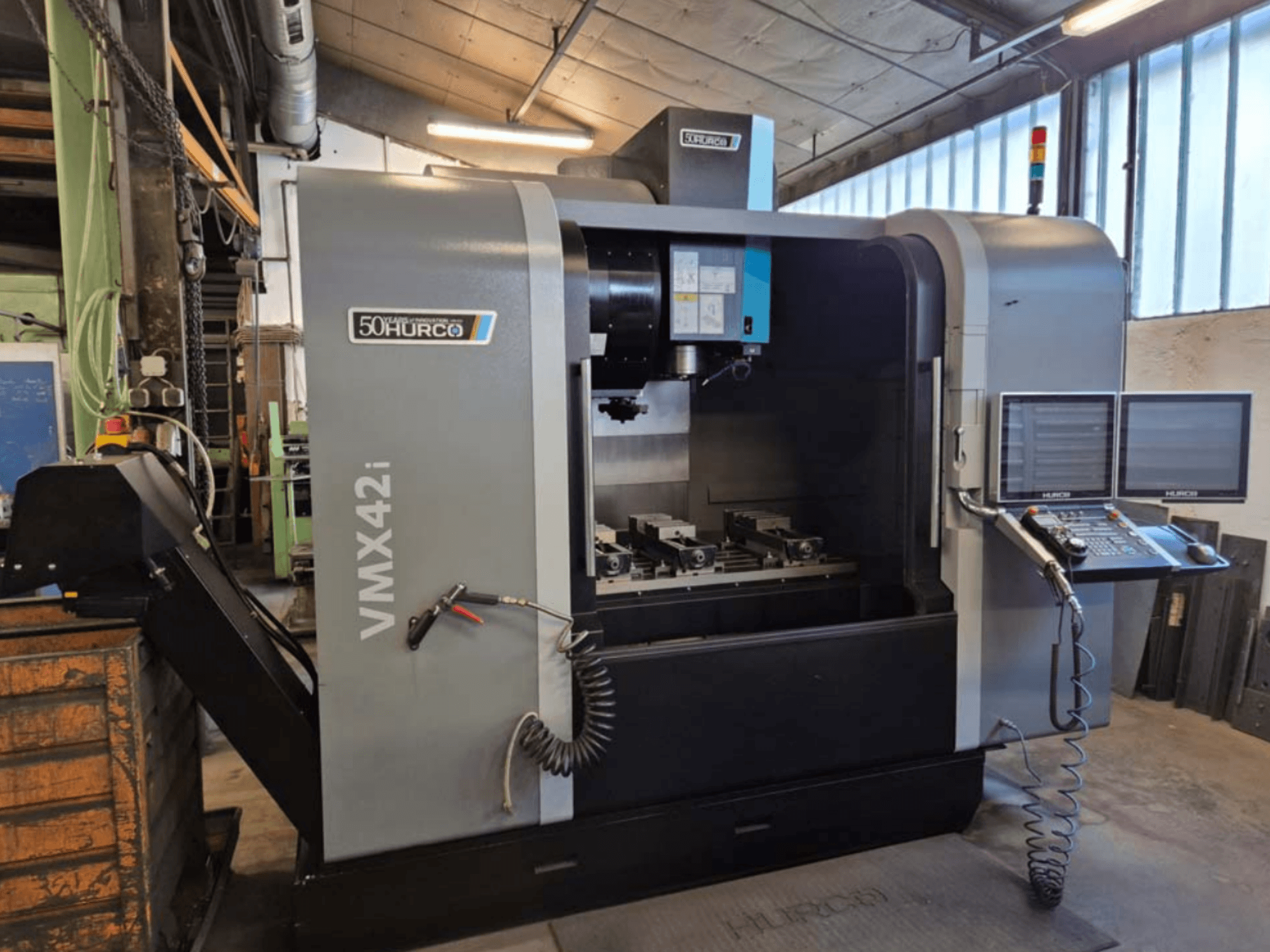 Hurco VMX 42i vertical machining center, front view, showcasing control panel and work area with vices.