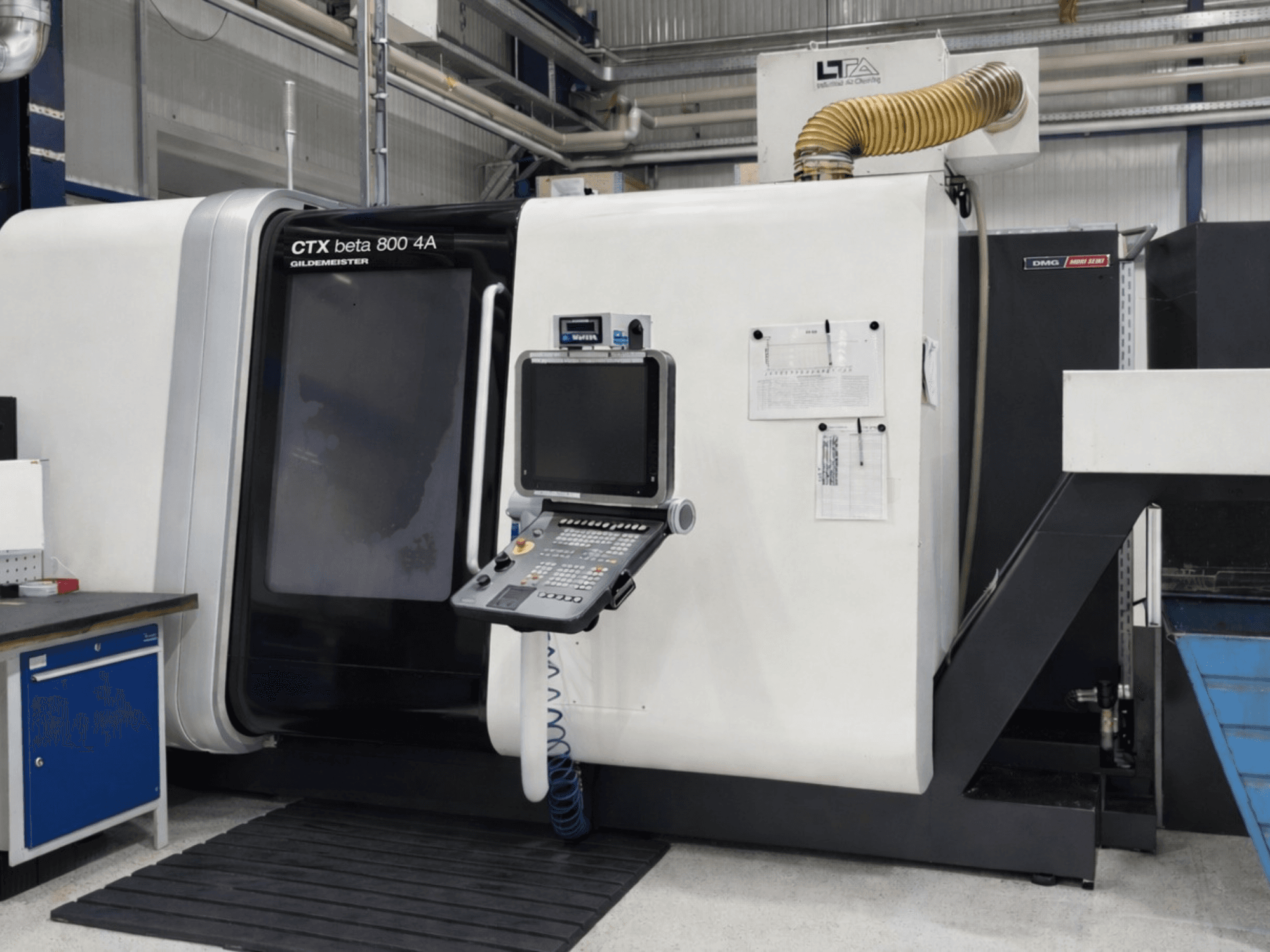 DMG CTX beta 800 4A multi-spindle turning machine, front view, featuring control panel and operational papers visible.