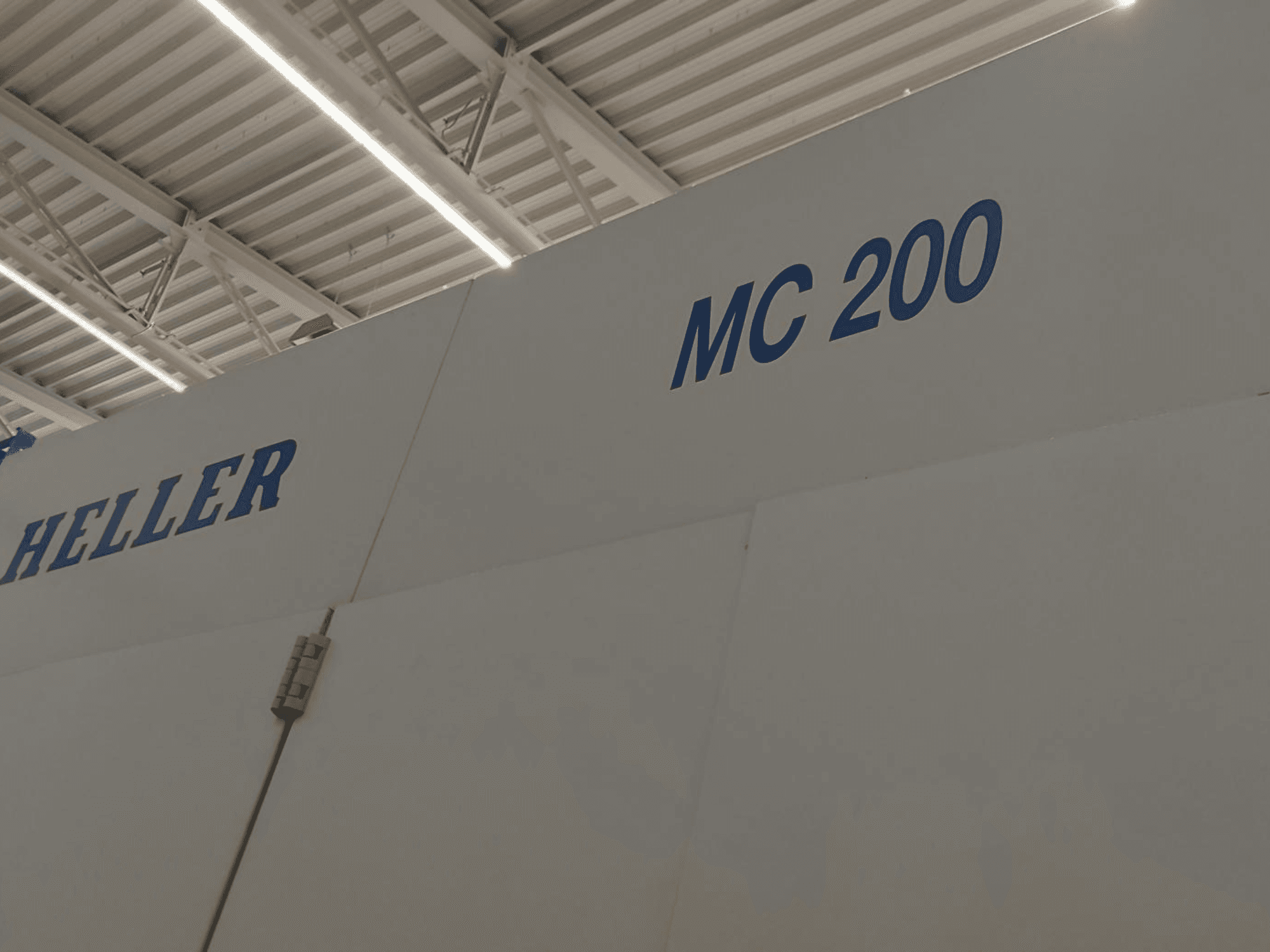Heller MC 200 horizontal machining centre, shown from the side, highlighting brand and model in blue lettering on a white surface.