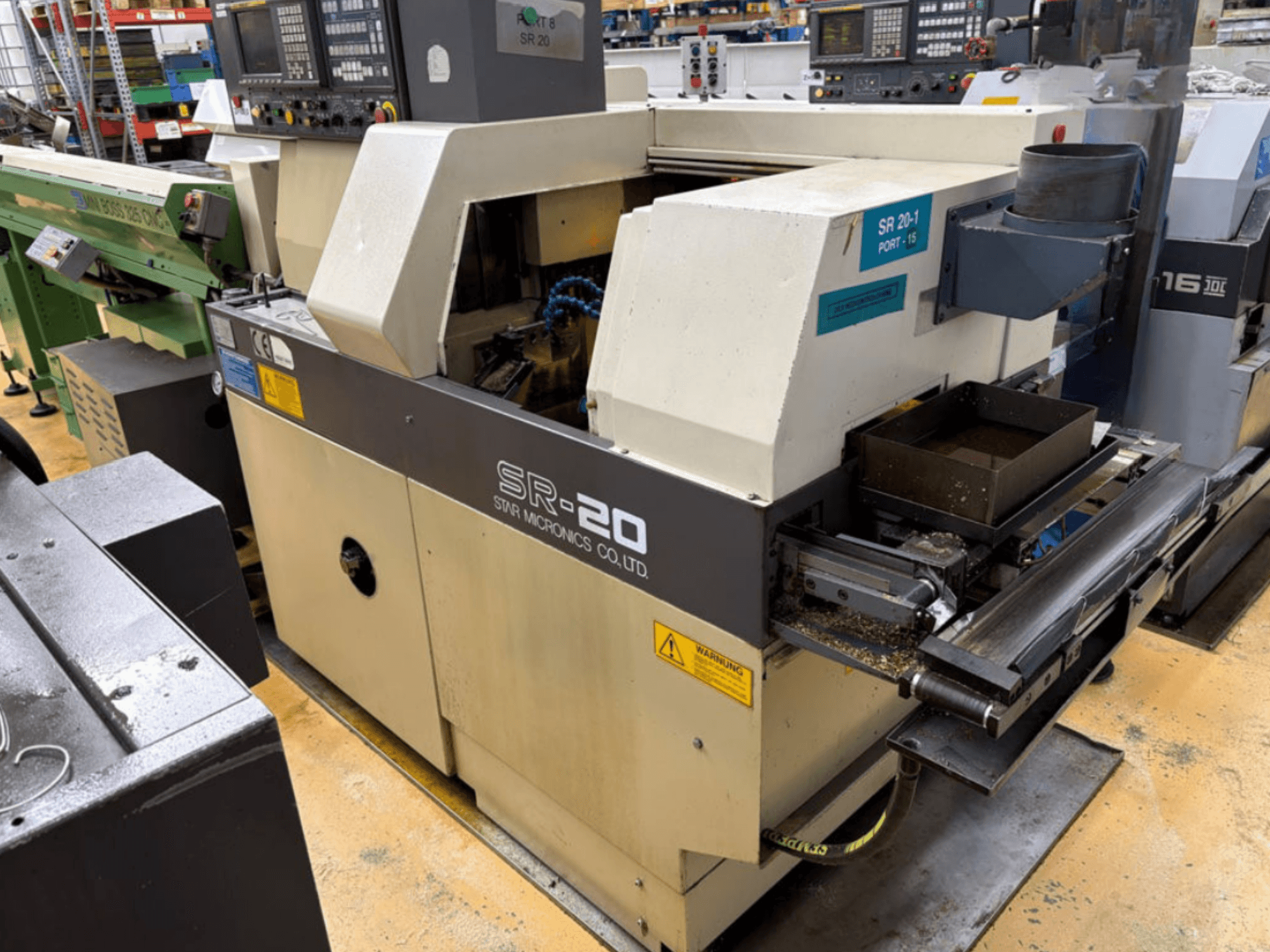 STAR MICRONICS SR20 Swiss type turning machine in side view, featuring control panel and tooling area with chips.