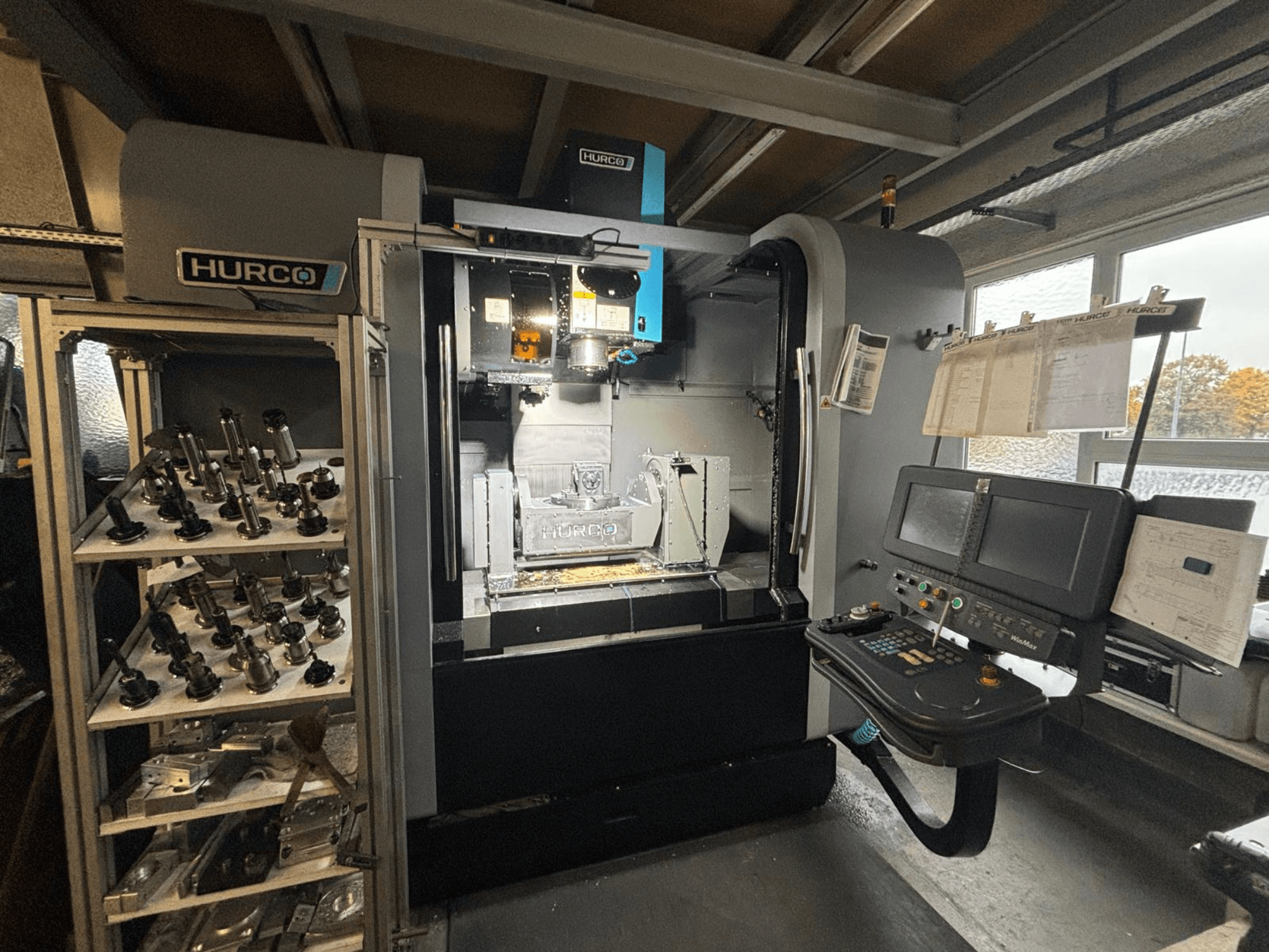 Hurco VMX42U vertical machining center in a front view, showcasing control panel, tools rack, and machining workspace.