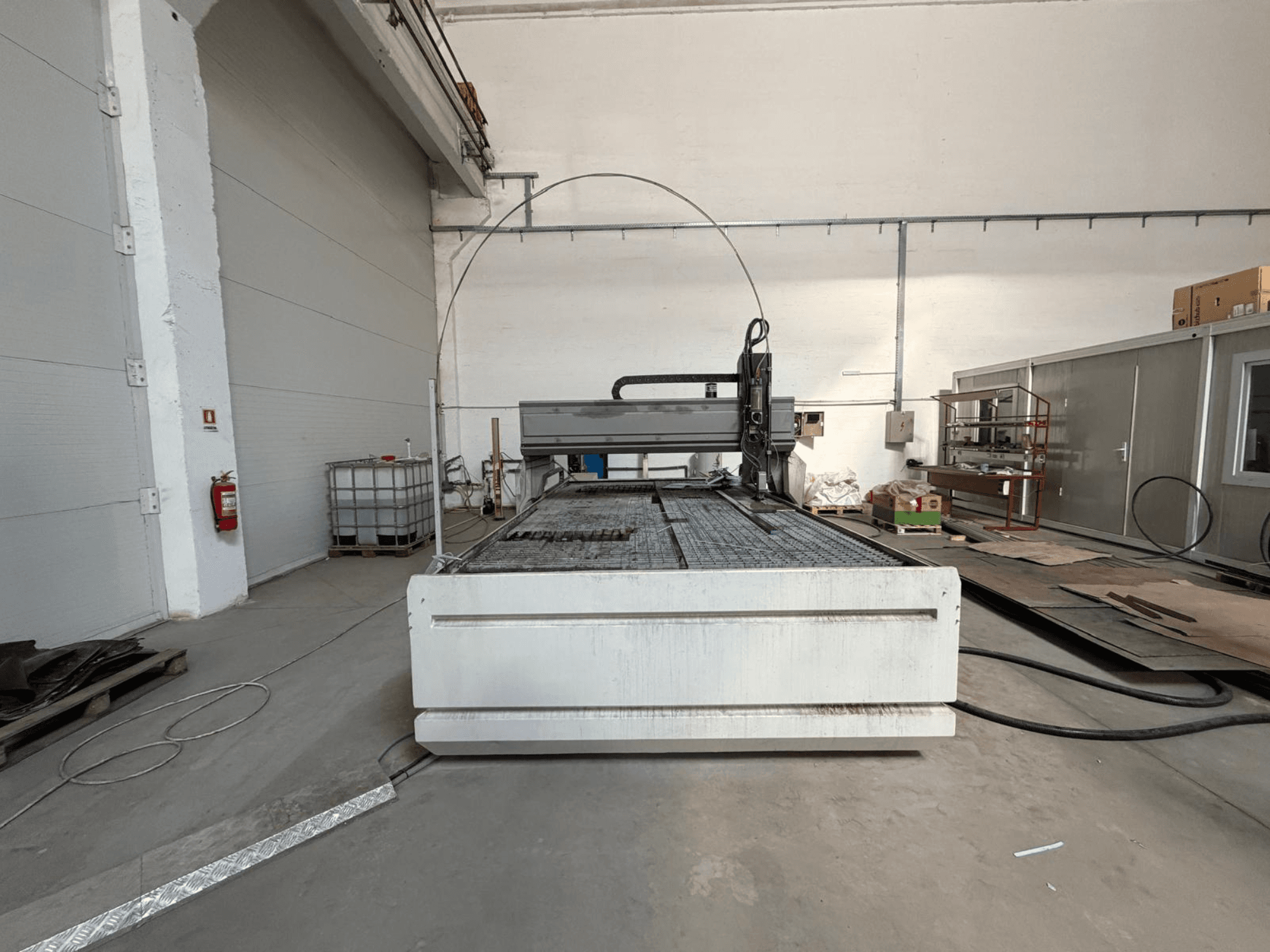CMS SMARTLINE 2040 waterjet cutting machine, front view, showcasing its large flat surface and industrial setting.