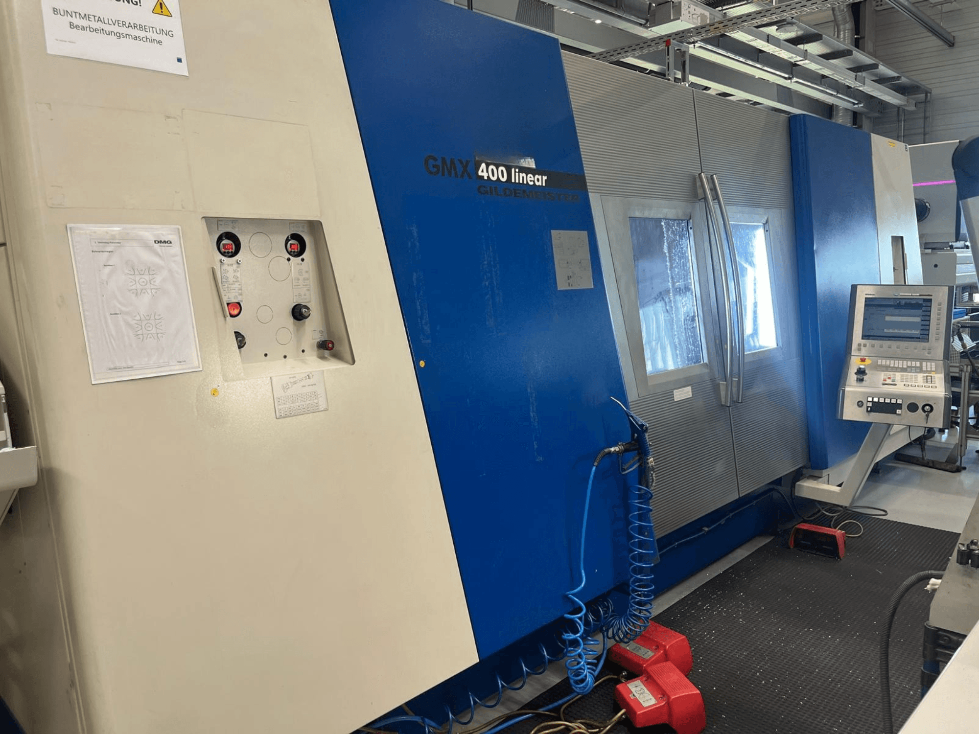 Gildemeister GMX 400 linear turn-mill centre, front view showing control panel, coolant system, and operational buttons.