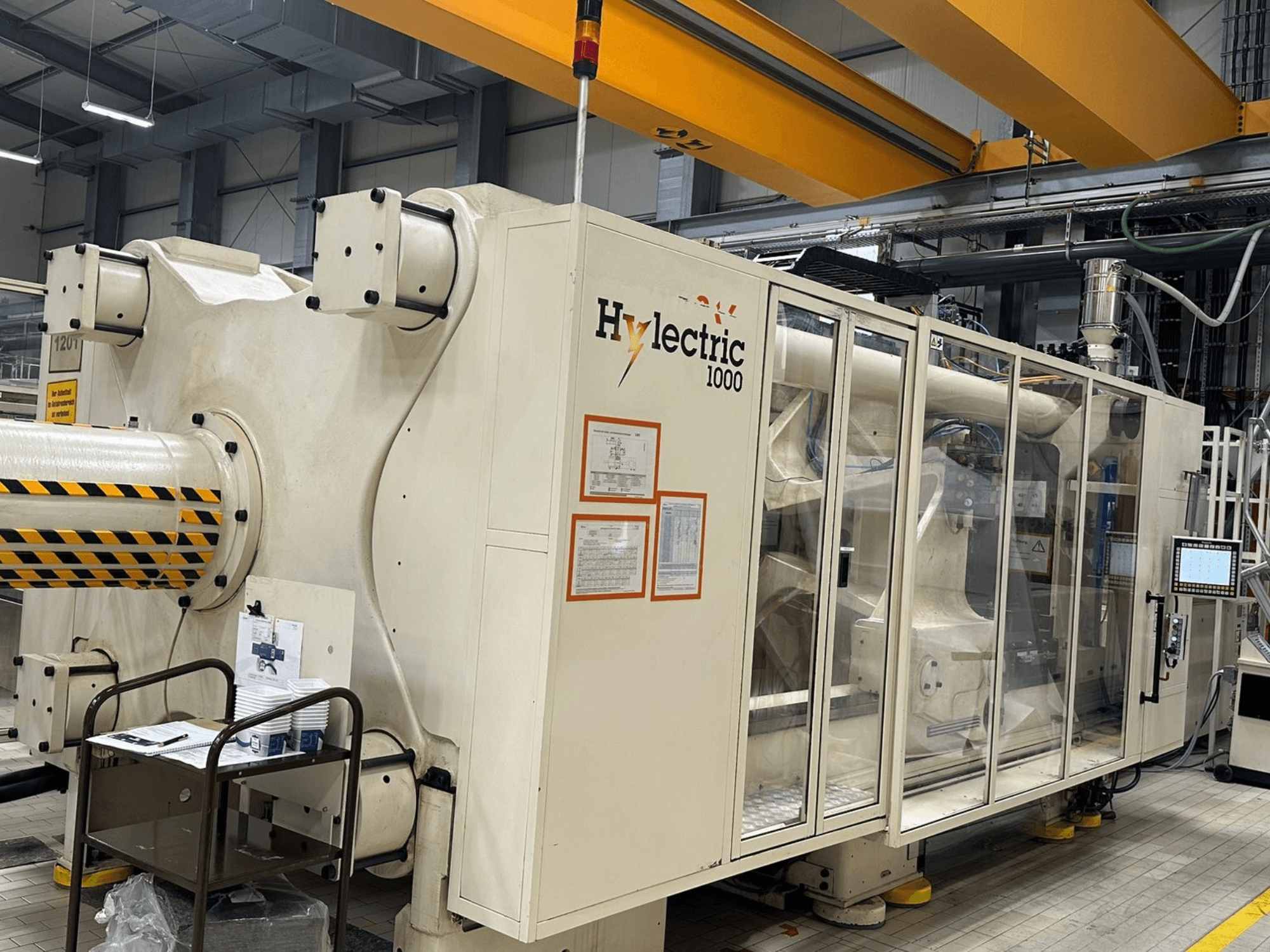 Husky Hylelectric H1000 RS95/80 electric injection moulding machine, side view with control panel and safety features visible.