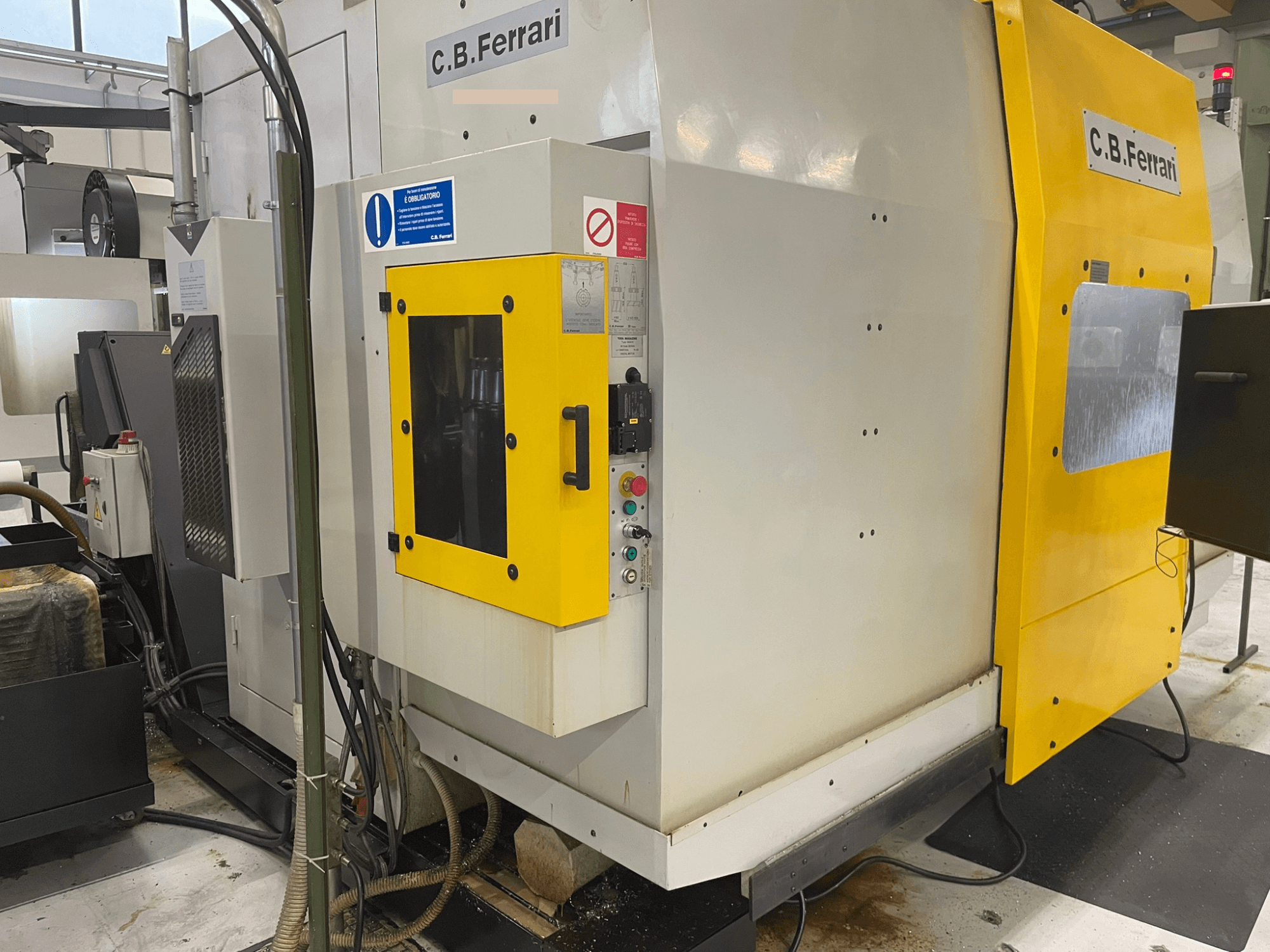 C.B. Ferrari industrial machine, front view; features yellow door, control panel, and visible machining components.
