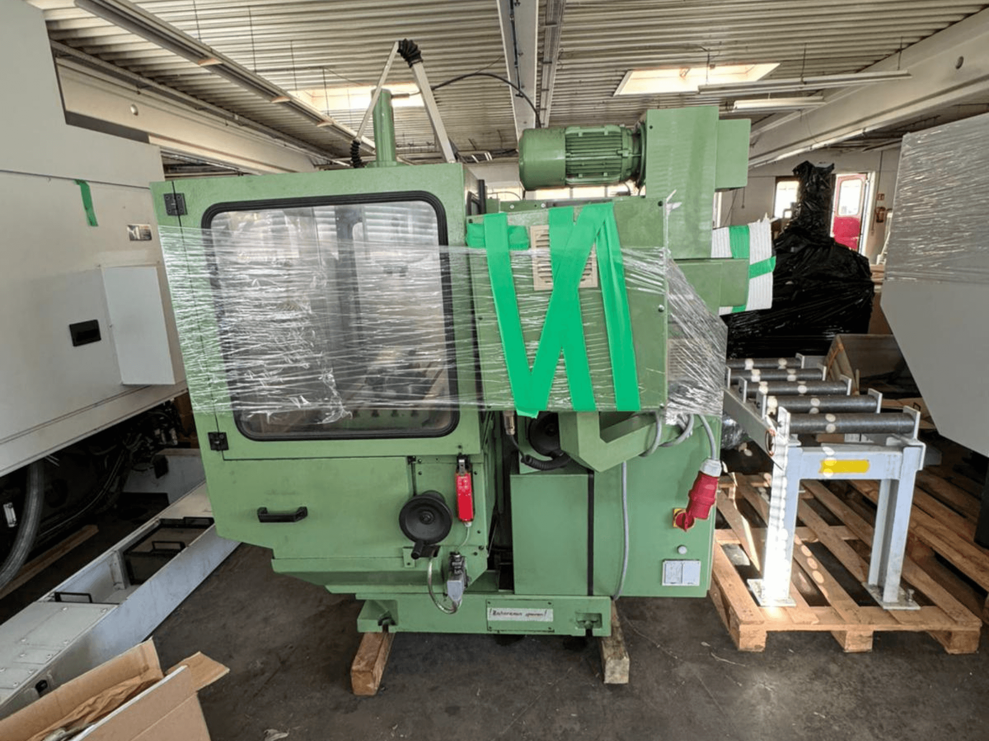 KUNZMANN WF 4/3 vertical machining centre in front view, wrapped in plastic, with green body and visible controls.