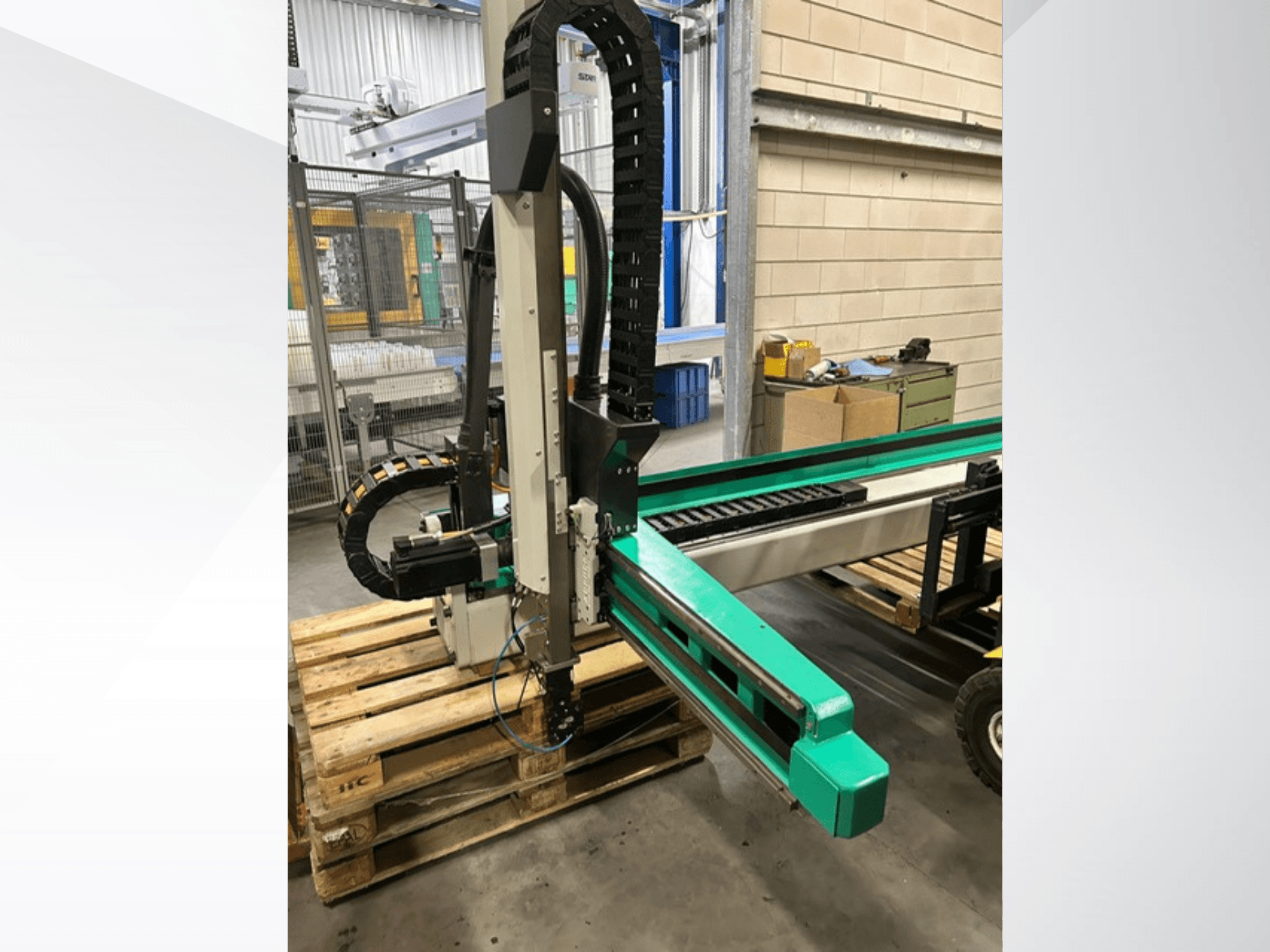 Arburg Multilift Select 15kg quer, side view of workpiece handling system on wooden pallets, showing robotic arm and control components.