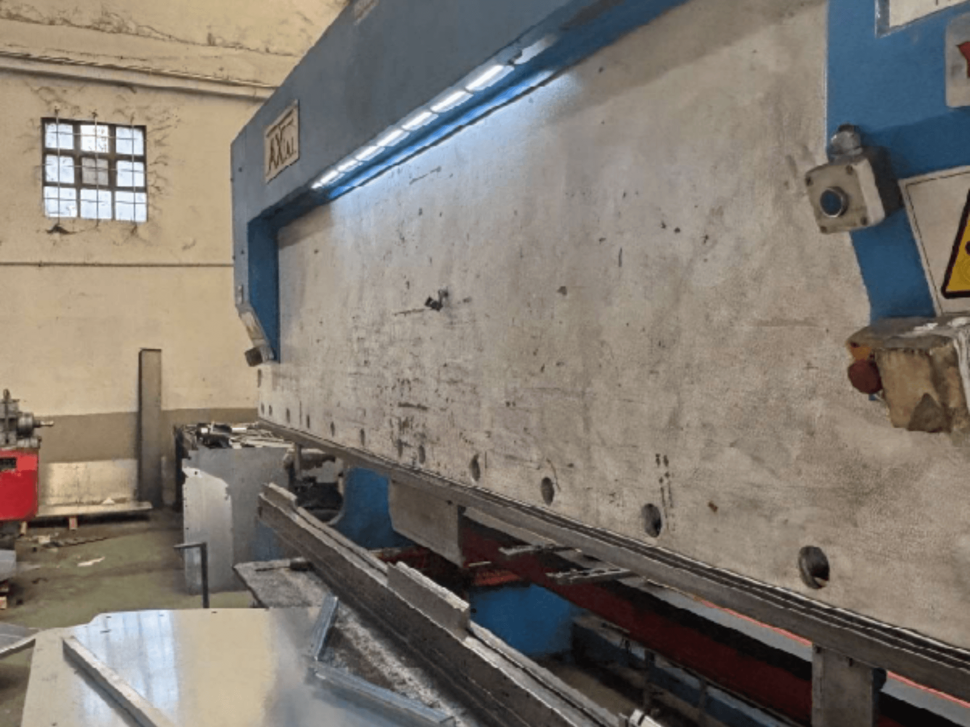 Axial PHS-W-124 pallet handling system in a workshop, side view showing working surface and control panel details.