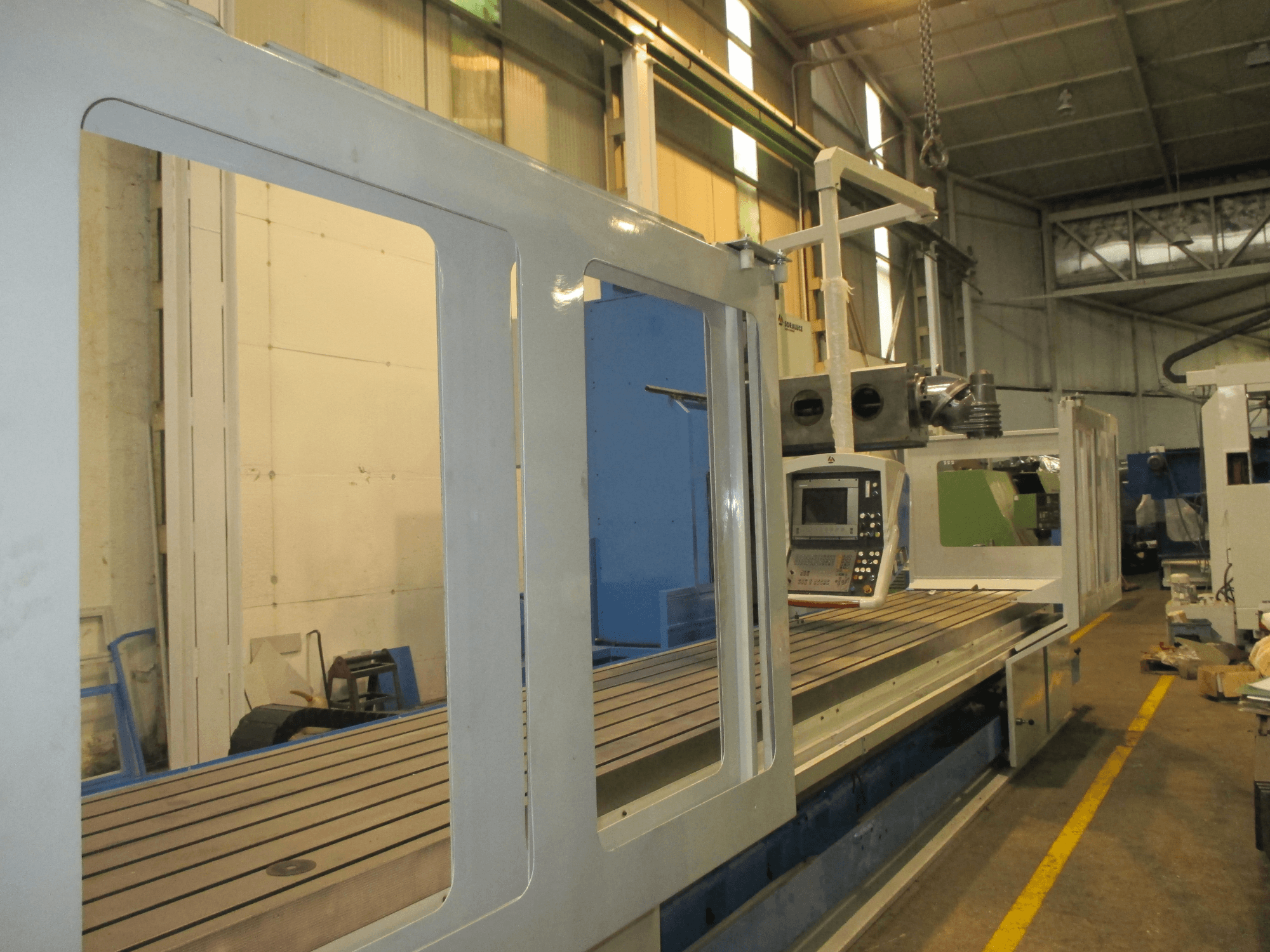 Soraluce SM 8000 bed type milling machine in side view, featuring control panel and metal work surface with grooves.