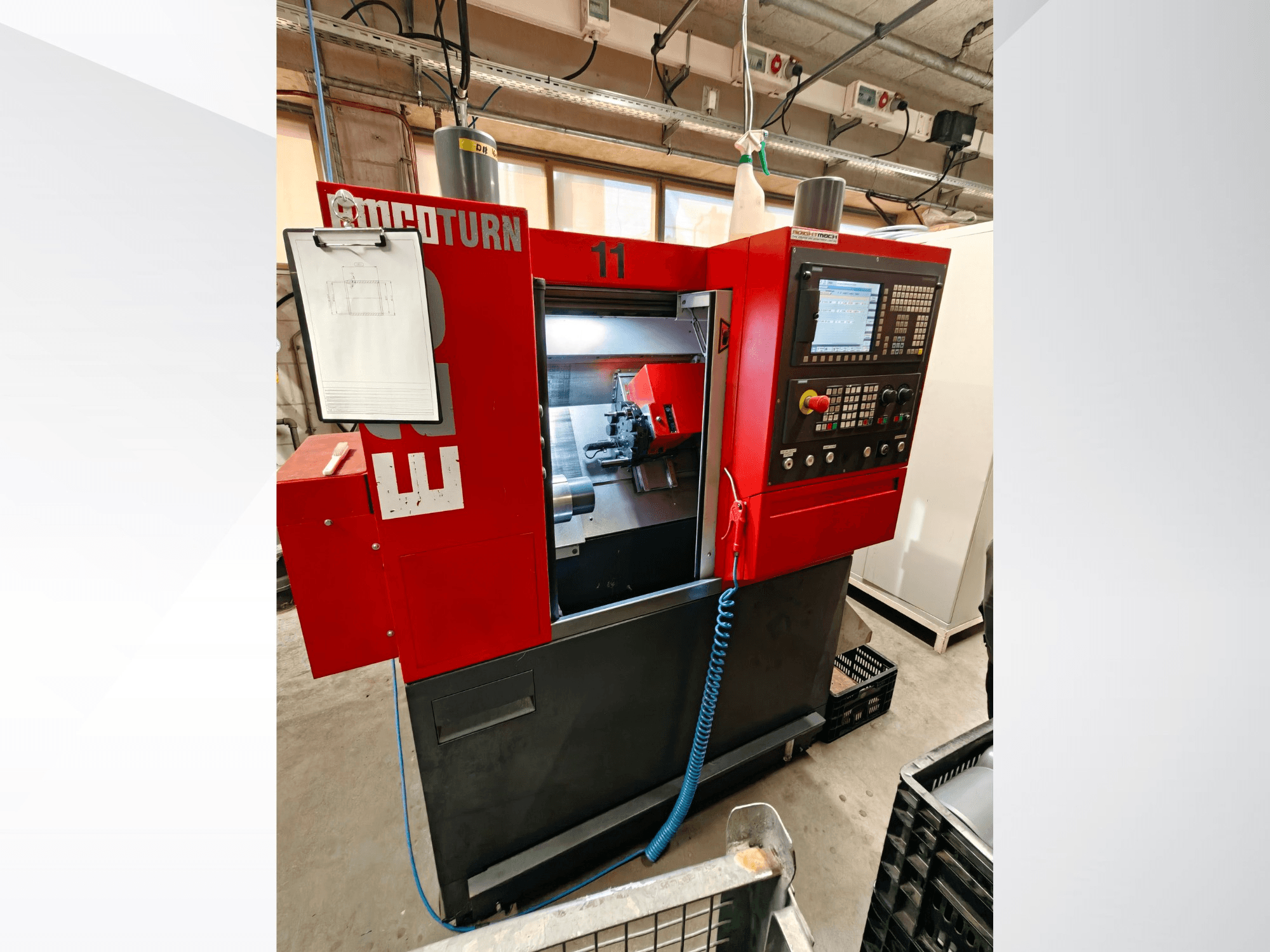 Red EMCO TURN E25 horizontal turning machine, front view, displaying control panel and spindle area in a workshop setting.