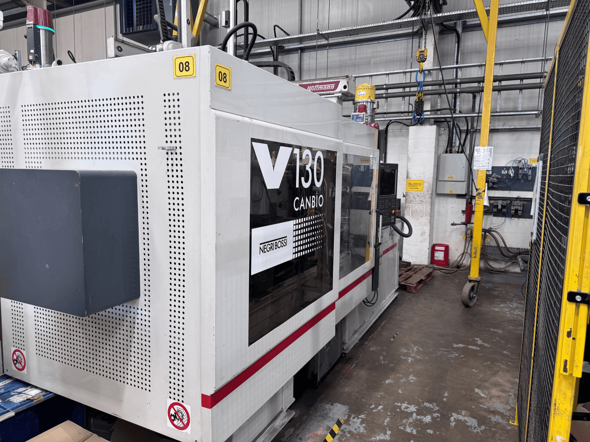 Negri Bossi 1300H-400 hydraulic injection moulding machine, side view, featuring control panel and safety signage.