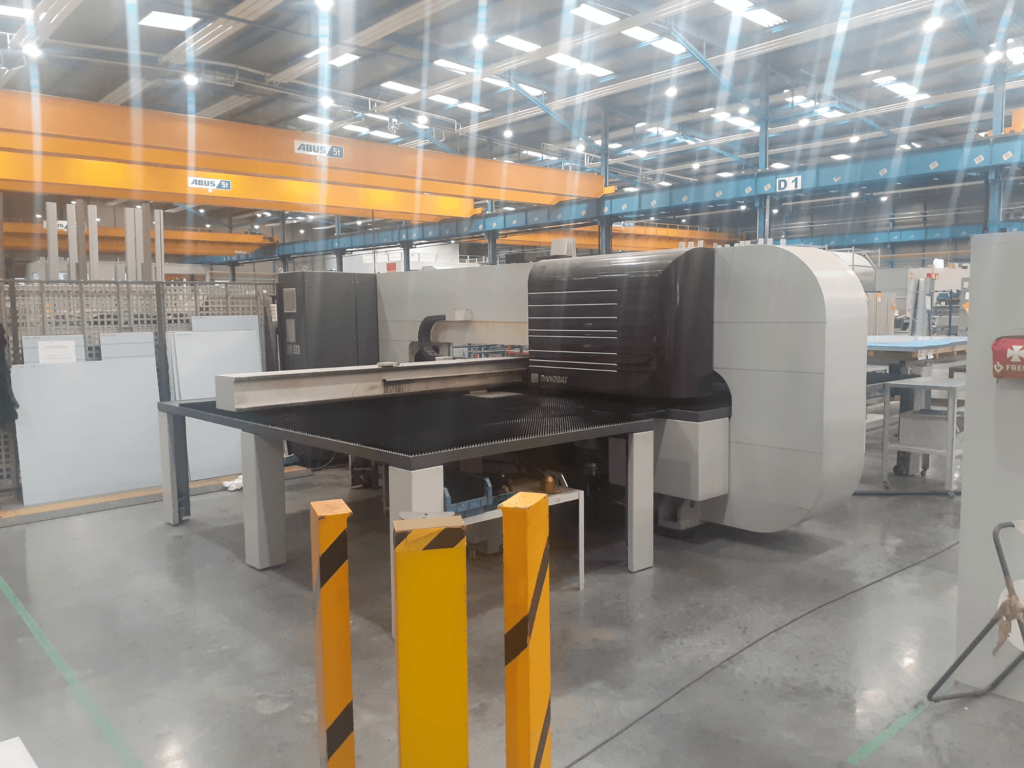 Cylindrical grinding machine DANOBAT CHROMA 30 in workshop, side view showing large table and safety barriers in foreground.