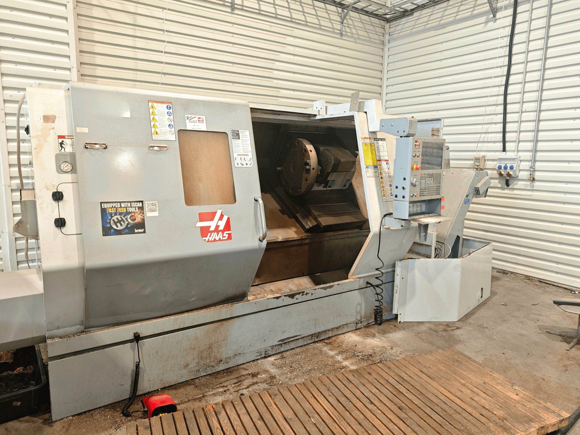 Haas SL-40HE horizontal turning machine, front view, showcasing control panel, work area, and safety labels.