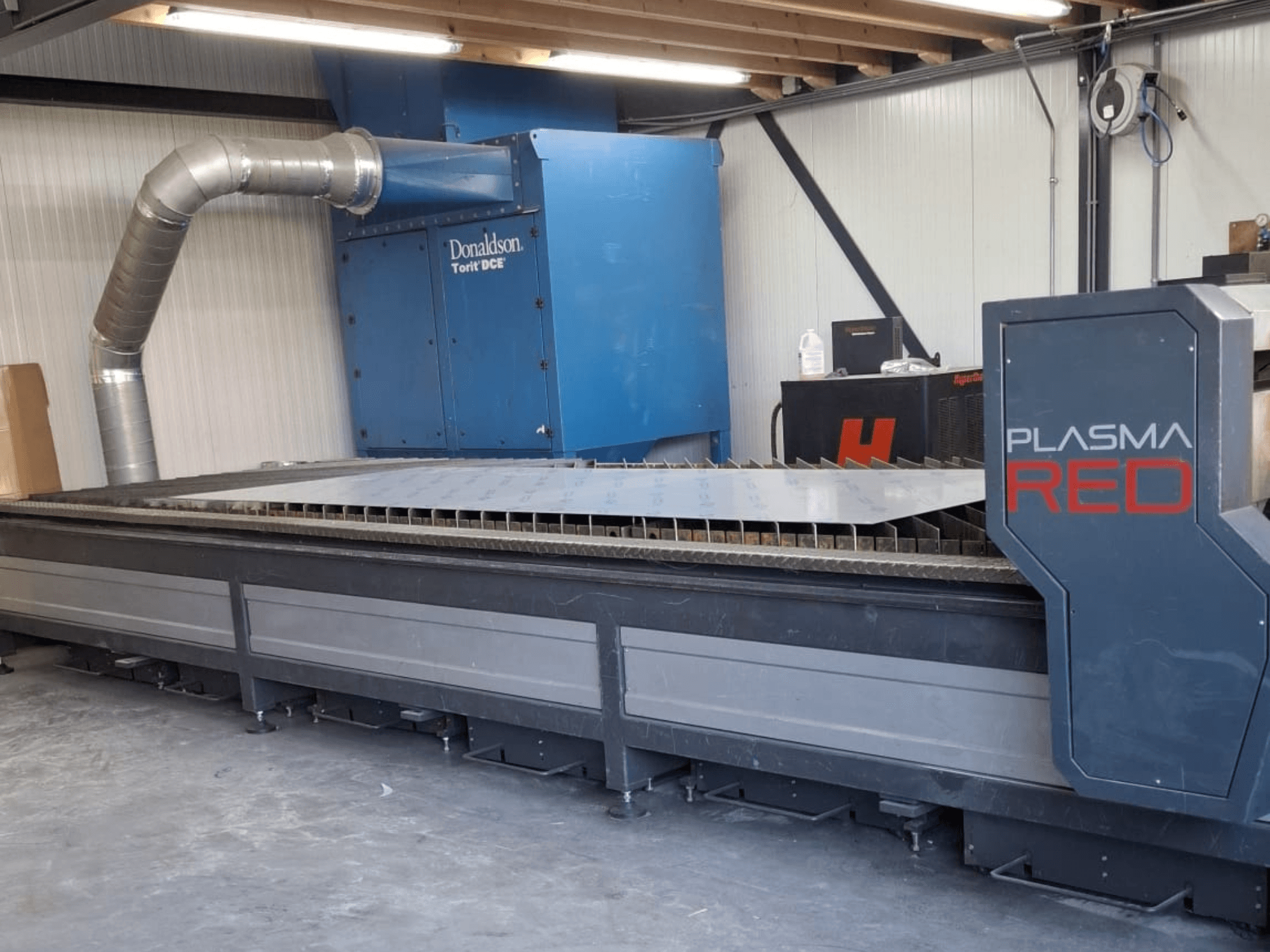 SOITAAB Plasmatech-Red plasma cutting machine in front view, featuring a wide cutting table and exhaust system.