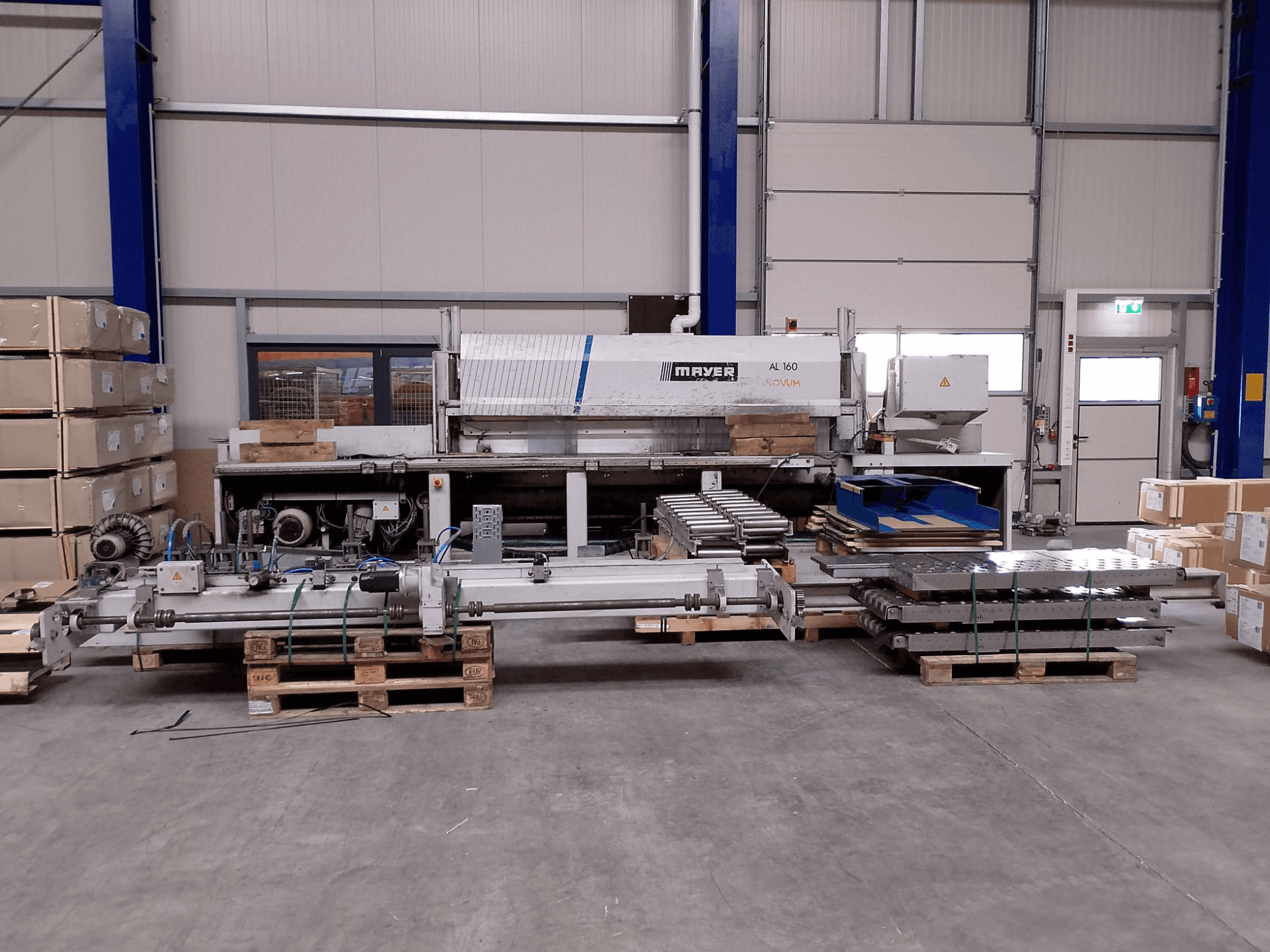 MAYER AL160 panel saw in a warehouse with pallets, showcasing its cutting table and machine components, front view.