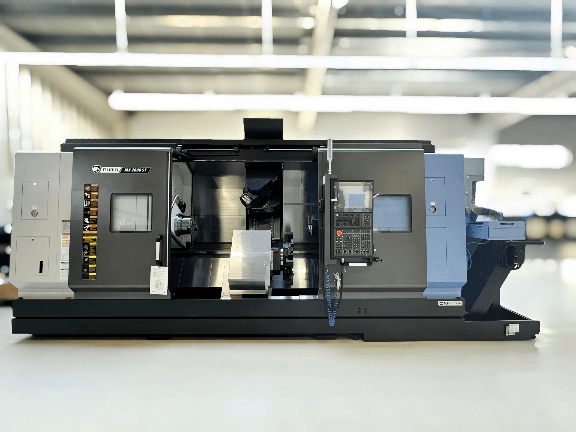 Puma MX2600ST Mill-Turn Centre in side view, featuring detailed control panel and machining area with visible tools.