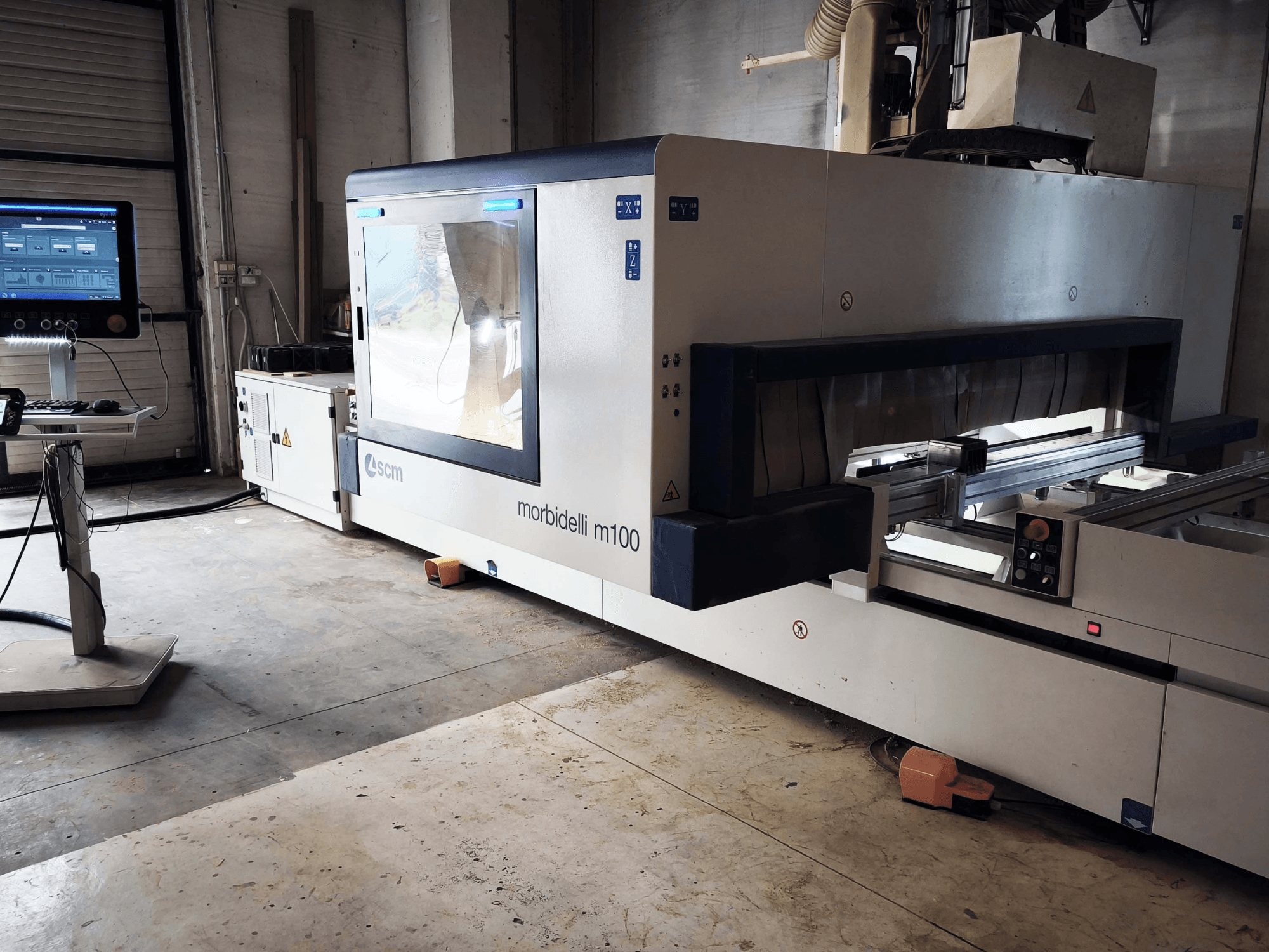 SCM morbidelli M 100 CNC wood machining center in side view, showcasing control panel, work area, and safety features.